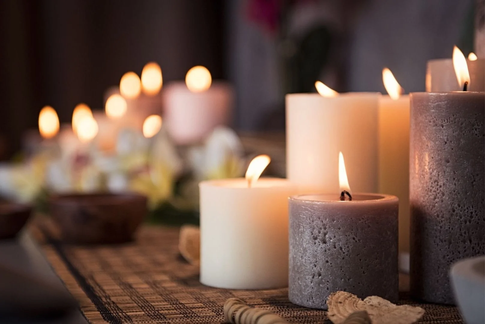 Lit candles on a woven mat, creating a warm and peaceful atmosphere.