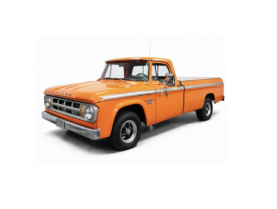 Vintage Dodge pickup truck parked outdoors with a clear sky and trees in the background.