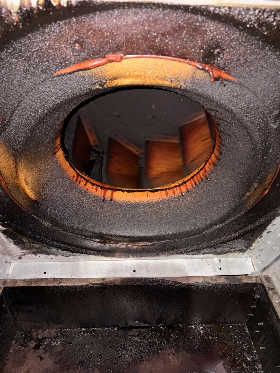 Before cleaning: heavy grease buildup around a commercial exhaust fan housing
