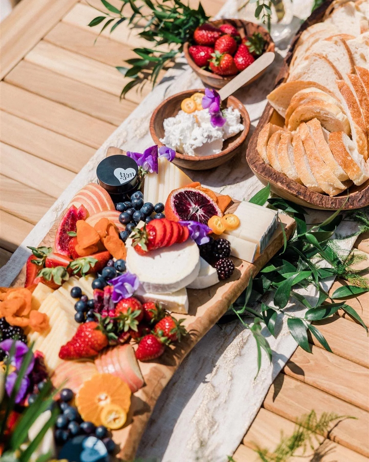 Beautiful charcuterie and cheese and fruit on a teak dining table