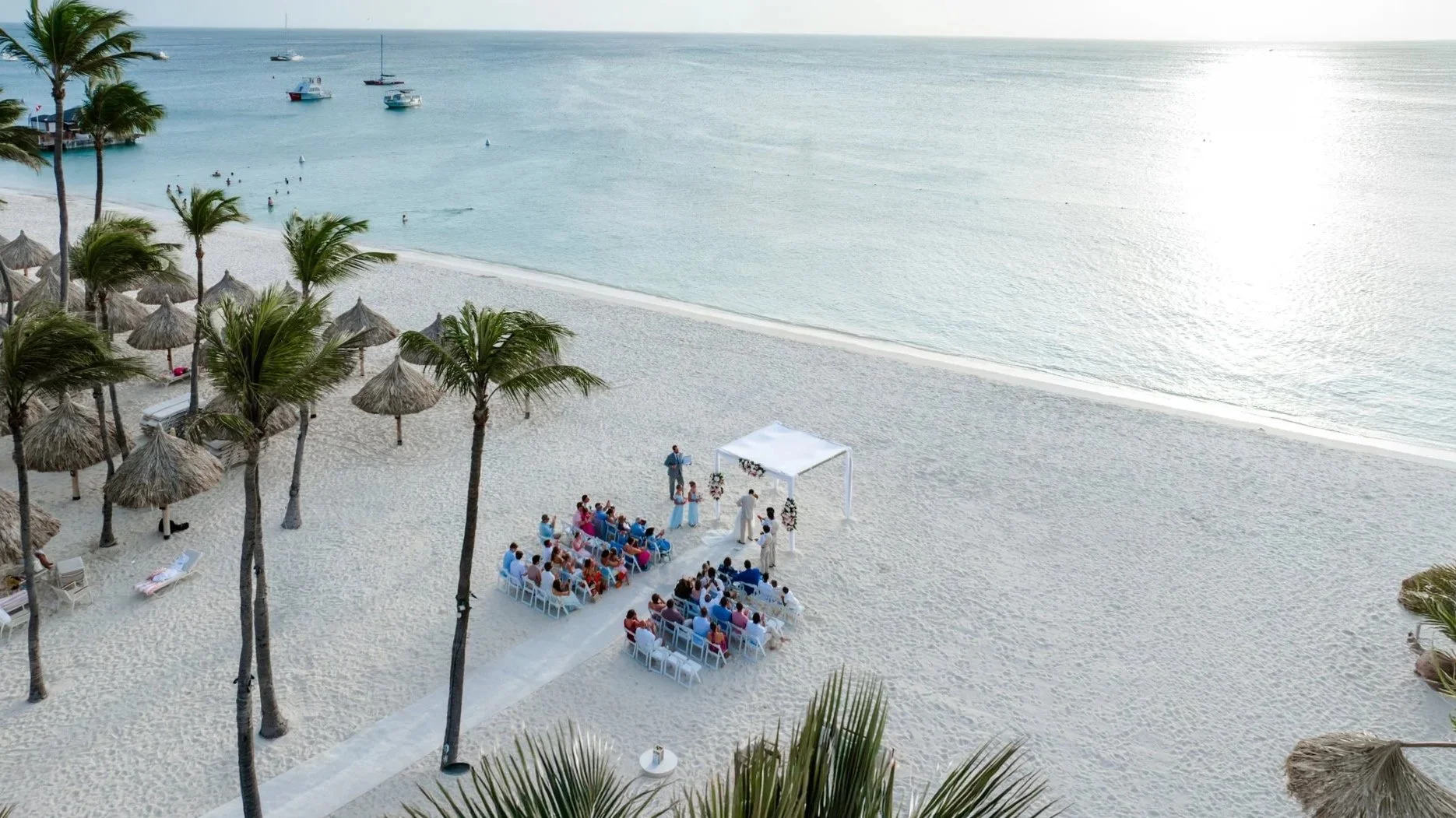 Aerial drone view of an Aruba beach wedding ceremony under the palms at Hyatt Regency Aruba Resort Spa and Casino, Palm Beach