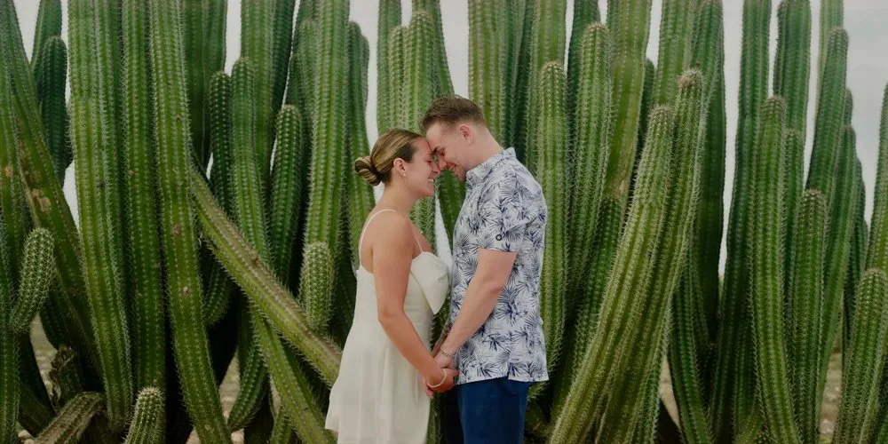 Aruba wedding couple among tall cactus during an adventure session with Aruba wedding videographer Wedding Films by Mira