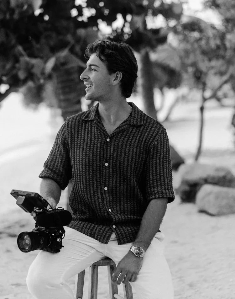 Aruba wedding videographer Tyler Cavallaro of Wedding Films by Mira, seated with his camera