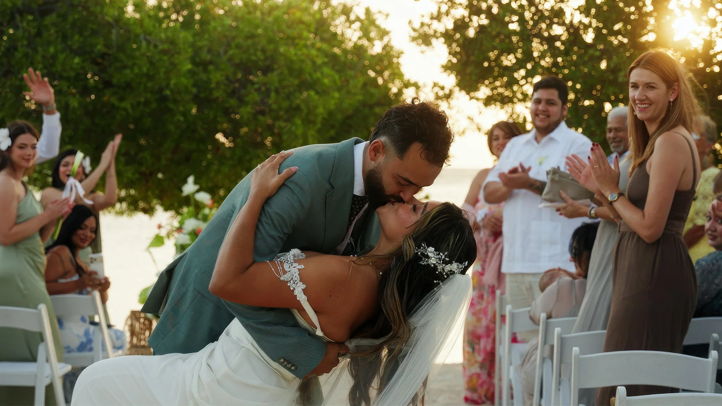 Bride and groom share a sunset kiss at their beach wedding ceremony on Surfside Beach, Aruba, filmed by Wedding Films by Mira