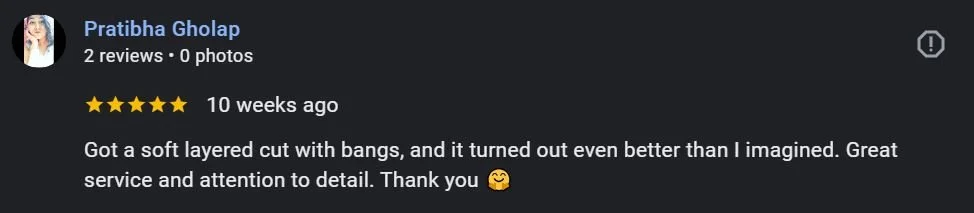 Screenshot of a positive online review from Pratibha Gholap, expressing satisfaction with a soft layered haircut with bangs and praising the service and attention to detail.