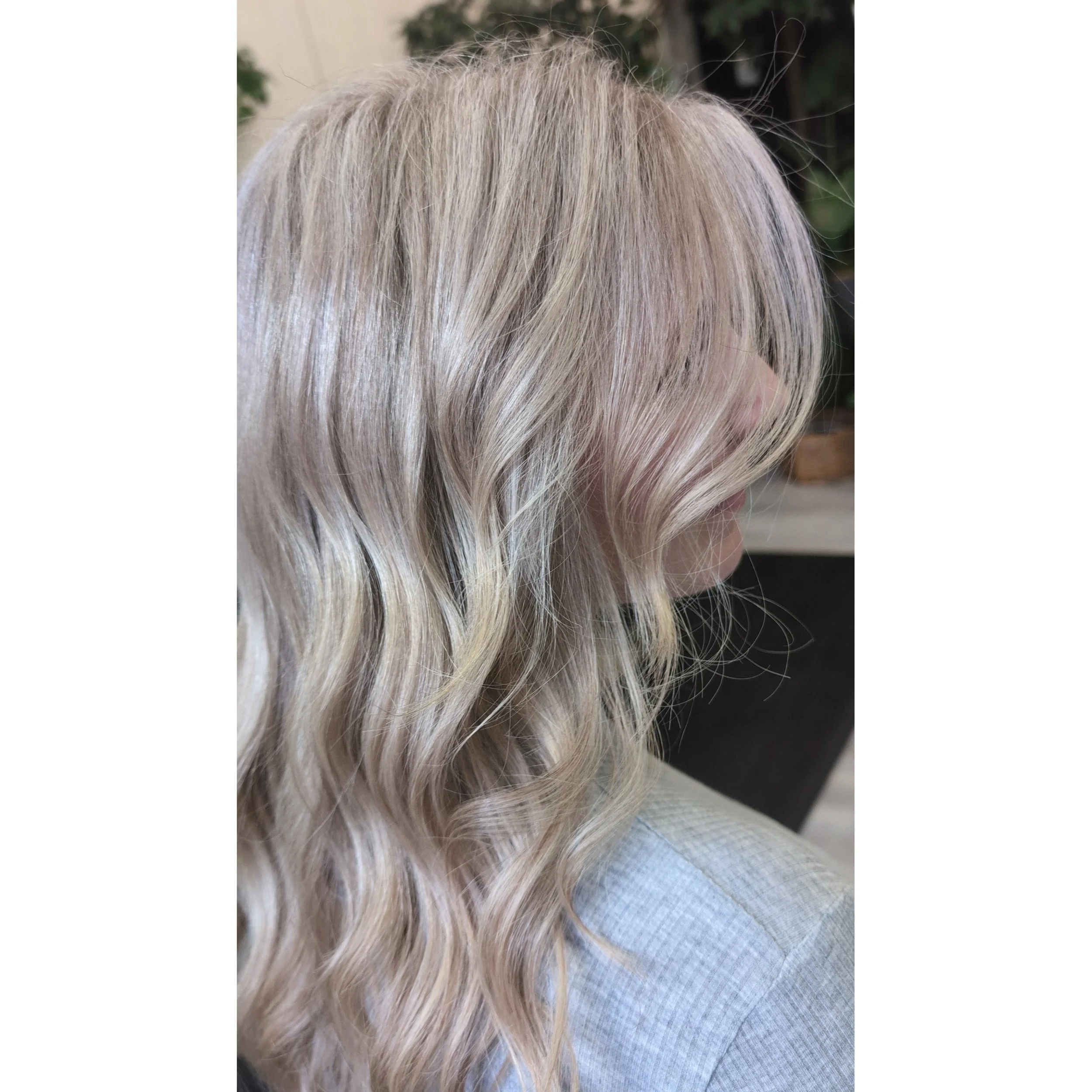 Side view of a woman with blonde, wavy hair.