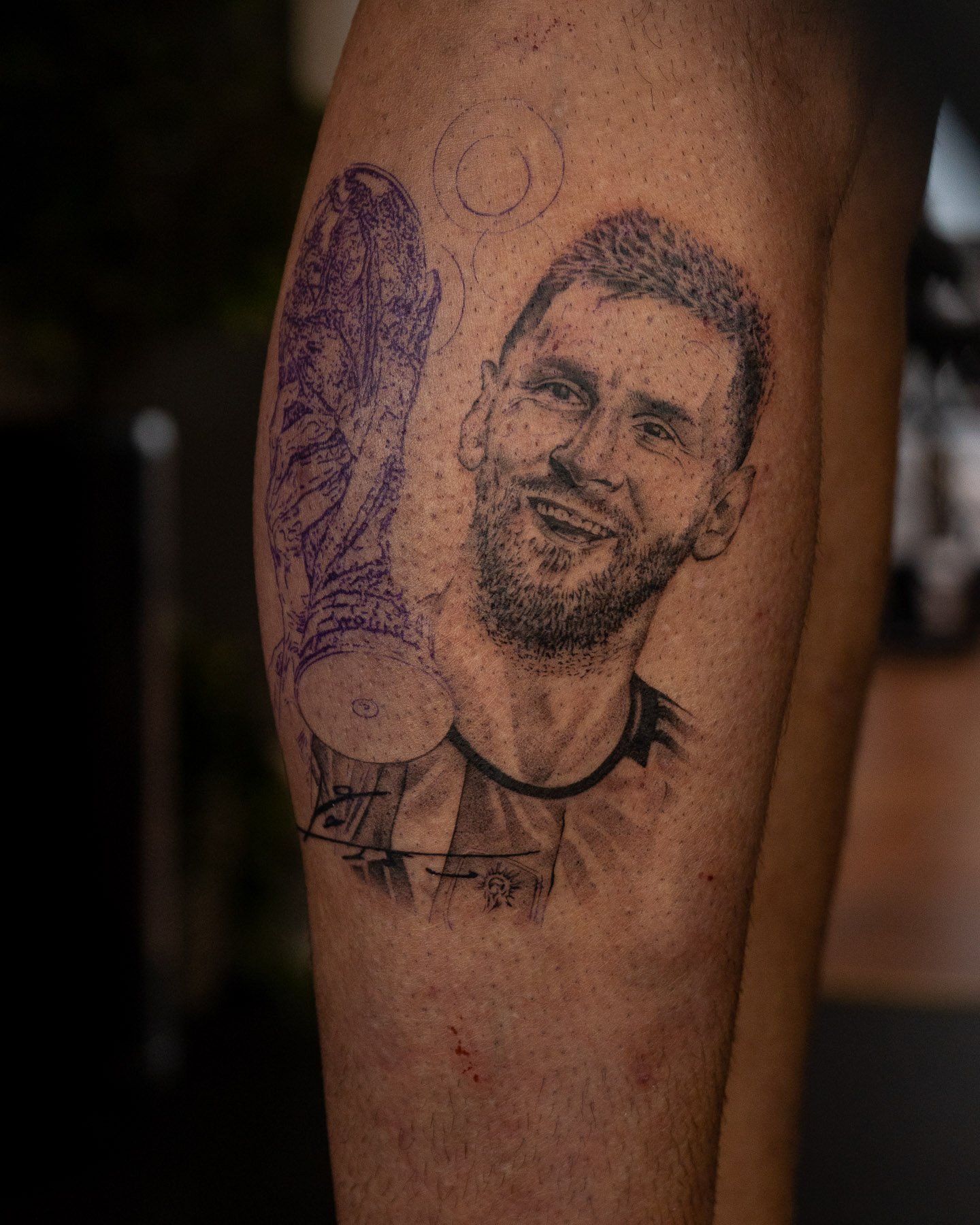 Tattoo of a smiling man holding a trophy on a person's leg.