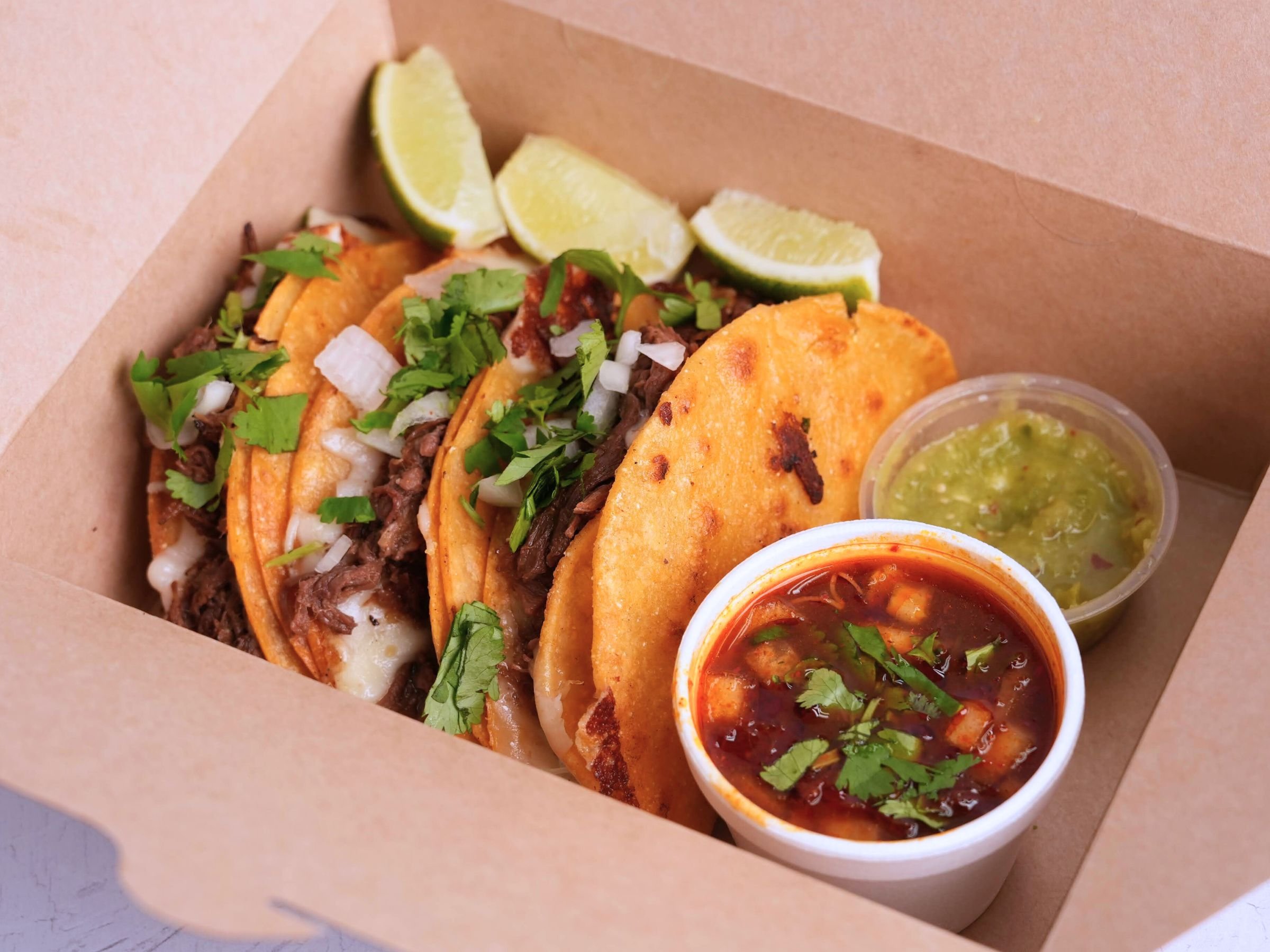 Korean Mexican birria tacos with consome salsa verde and lime