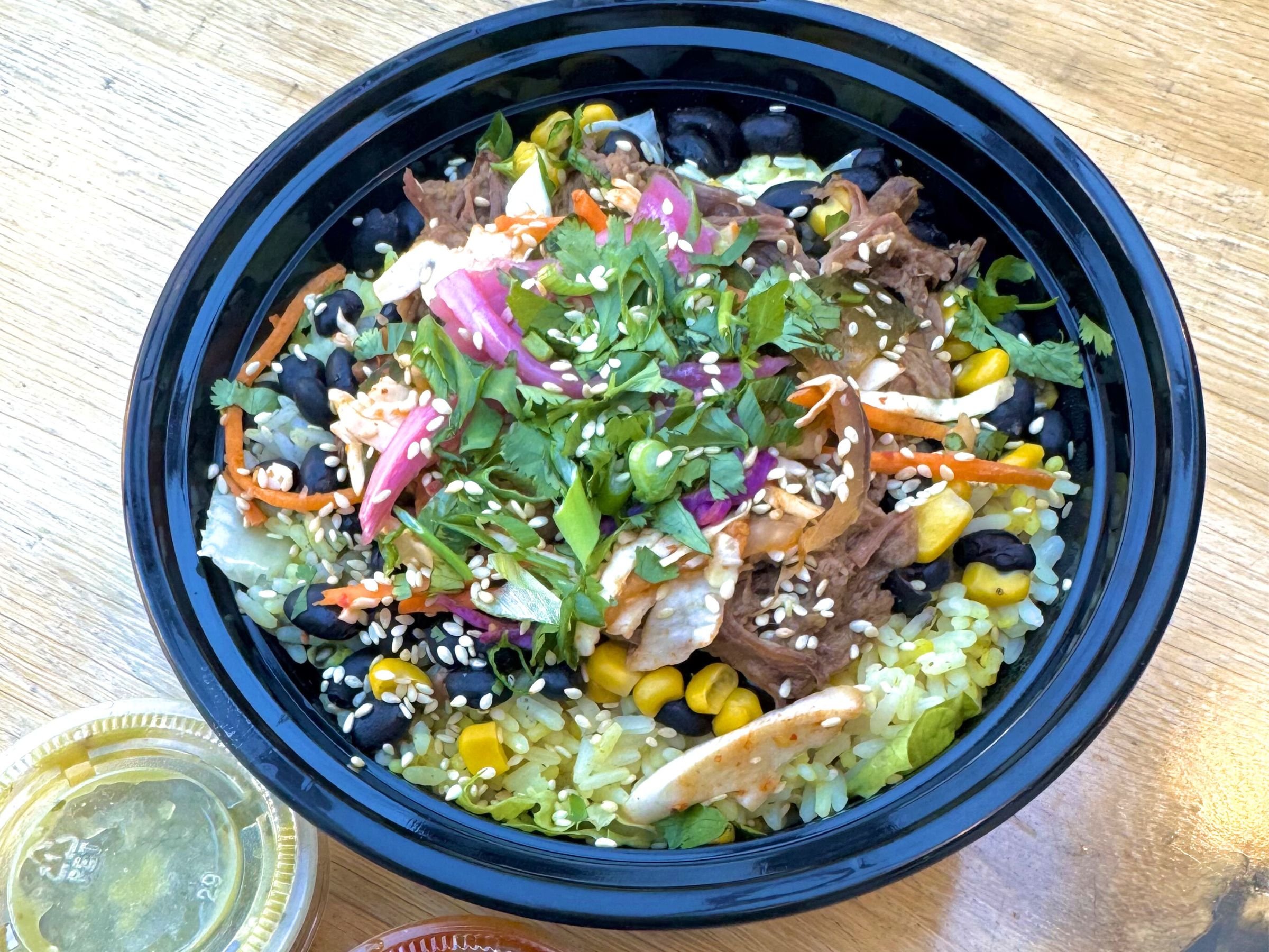 Korean rice bowl with bulgogi beef beans corn and fresh toppings
