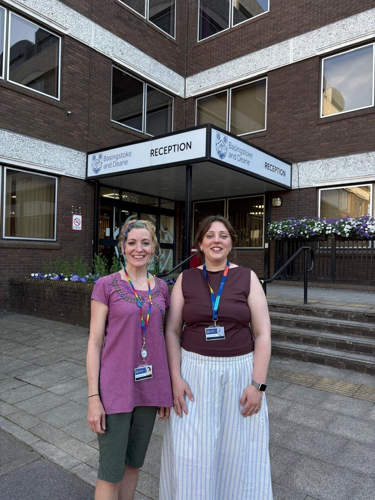 Two people standing outside the council offices