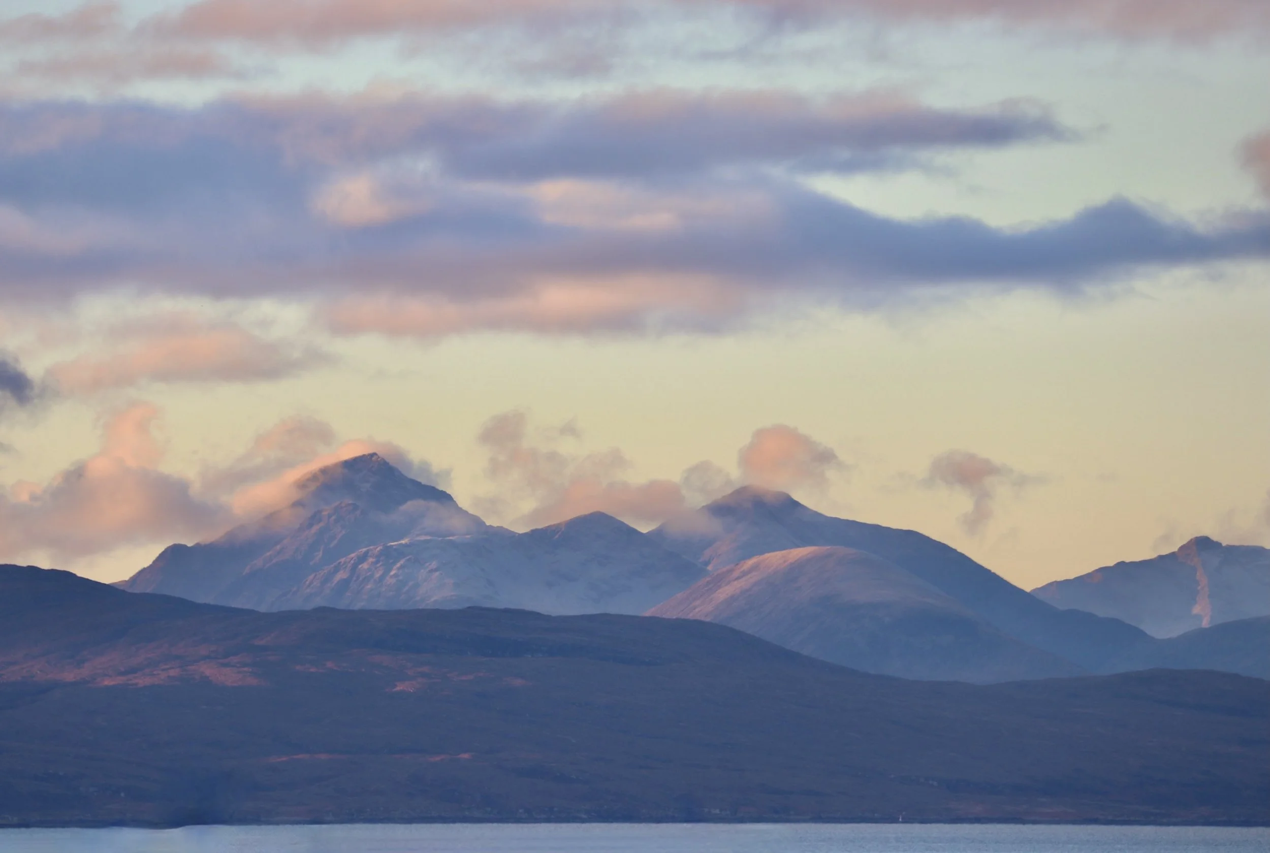Mountain view from Applecross under a sky with clouds at sunset or sunrise.