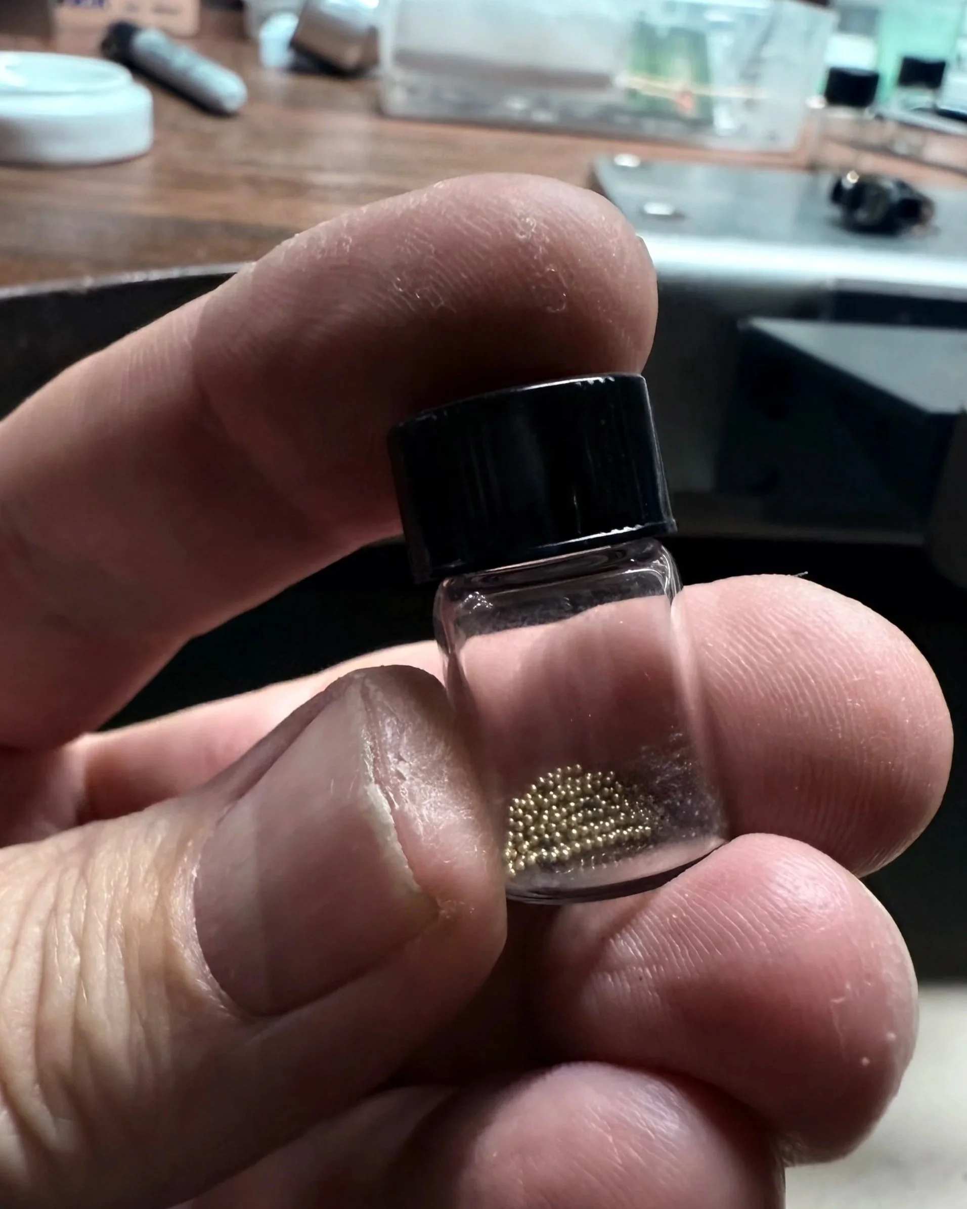 Goldsmithing process at the bench during the preparation of individual gold granules for traditional granulation.