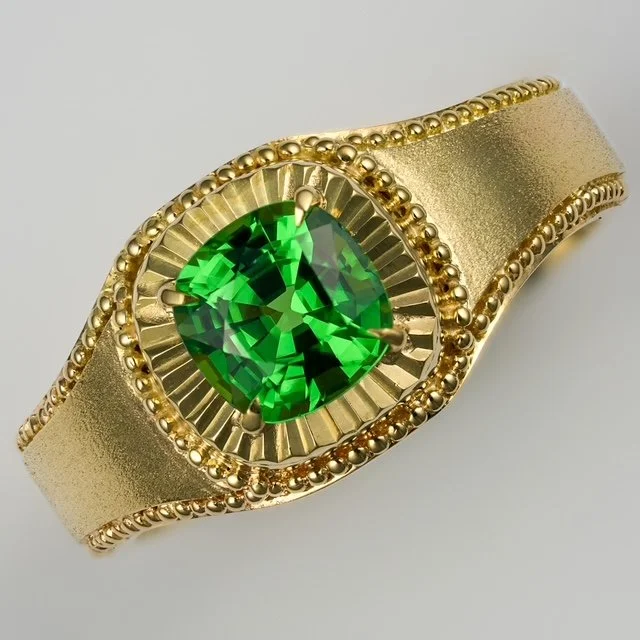 Hand-made 18k gold ring set with a vivid green gemstone, featuring sculptural granulation and architectural detailing