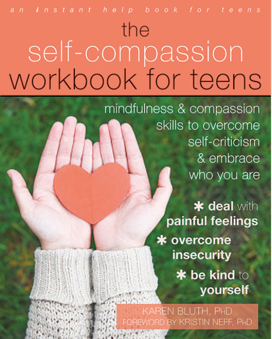 Book cover titled "The Self-Compassion Workbook for Teens" featuring a pair of hands holding a paper heart against a green grassy background.