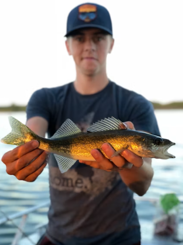 A man holding a walleye fish.
