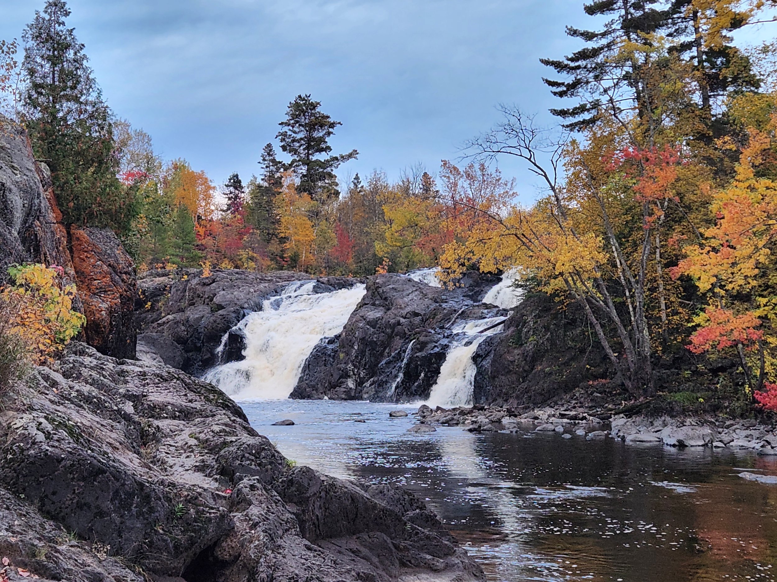 Waterfall surrounded by colorful autumn foliage and rocky terrain