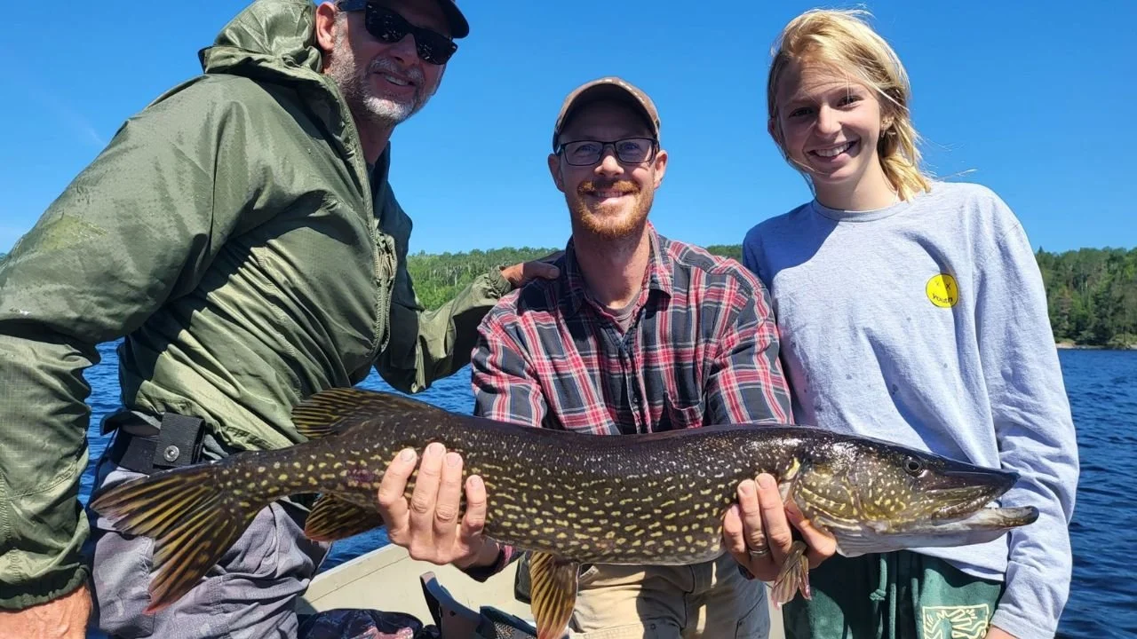 A fishing guide holding a large northern pike.