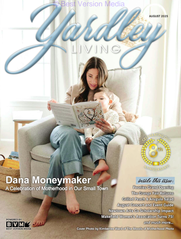 Cover of Yardley Living magazine, August 2025 issue, featuring a woman and child reading a book together on a cozy armchair in a bright living room, with the headline 'Dana Moneymaker, A Celebration of Motherhood in Our Small Town' and various article titles.