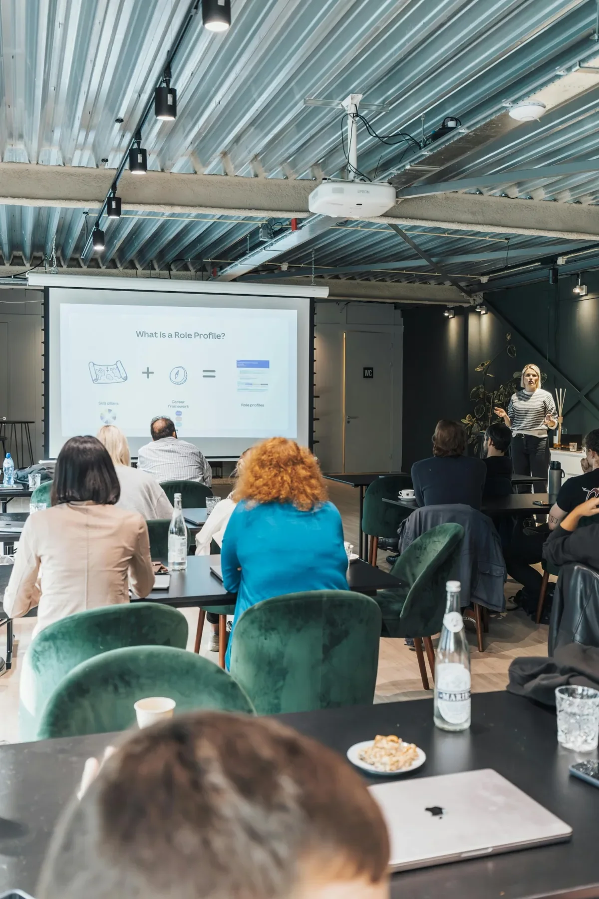 Professional seminar audience watching a presenter, representing psychology-informed leadership training and professional education.