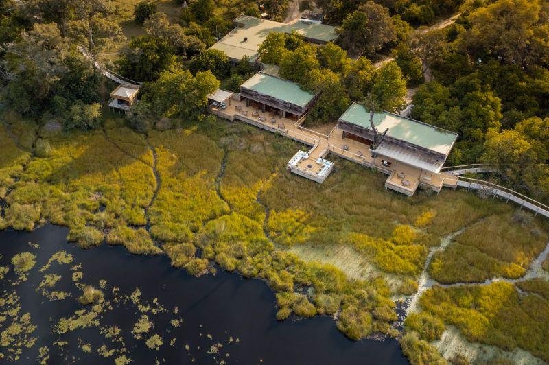 Lone boat crossing the Okavango channels. Protecting vast wilderness with relatively few guest beds is part of what makes low-density safari travel both costly and consequential.