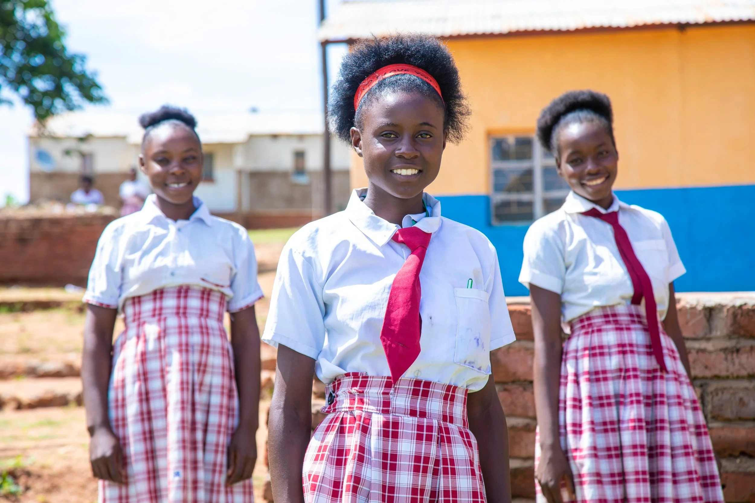 Group of schoolgirls in schoolyard, household energy access program, Zambia