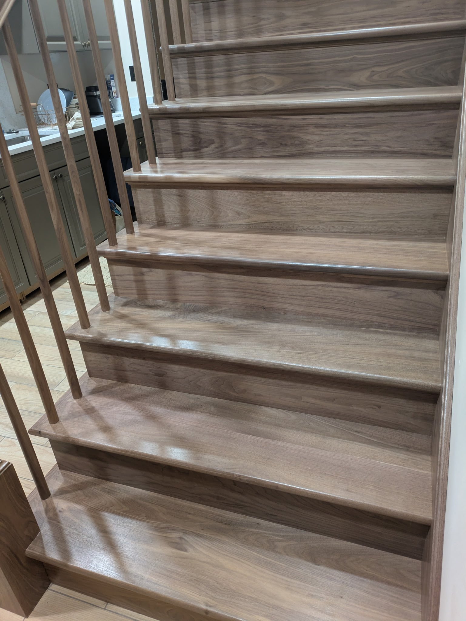 Wooden staircase with open steps and a railing, located in a modern home interior.
