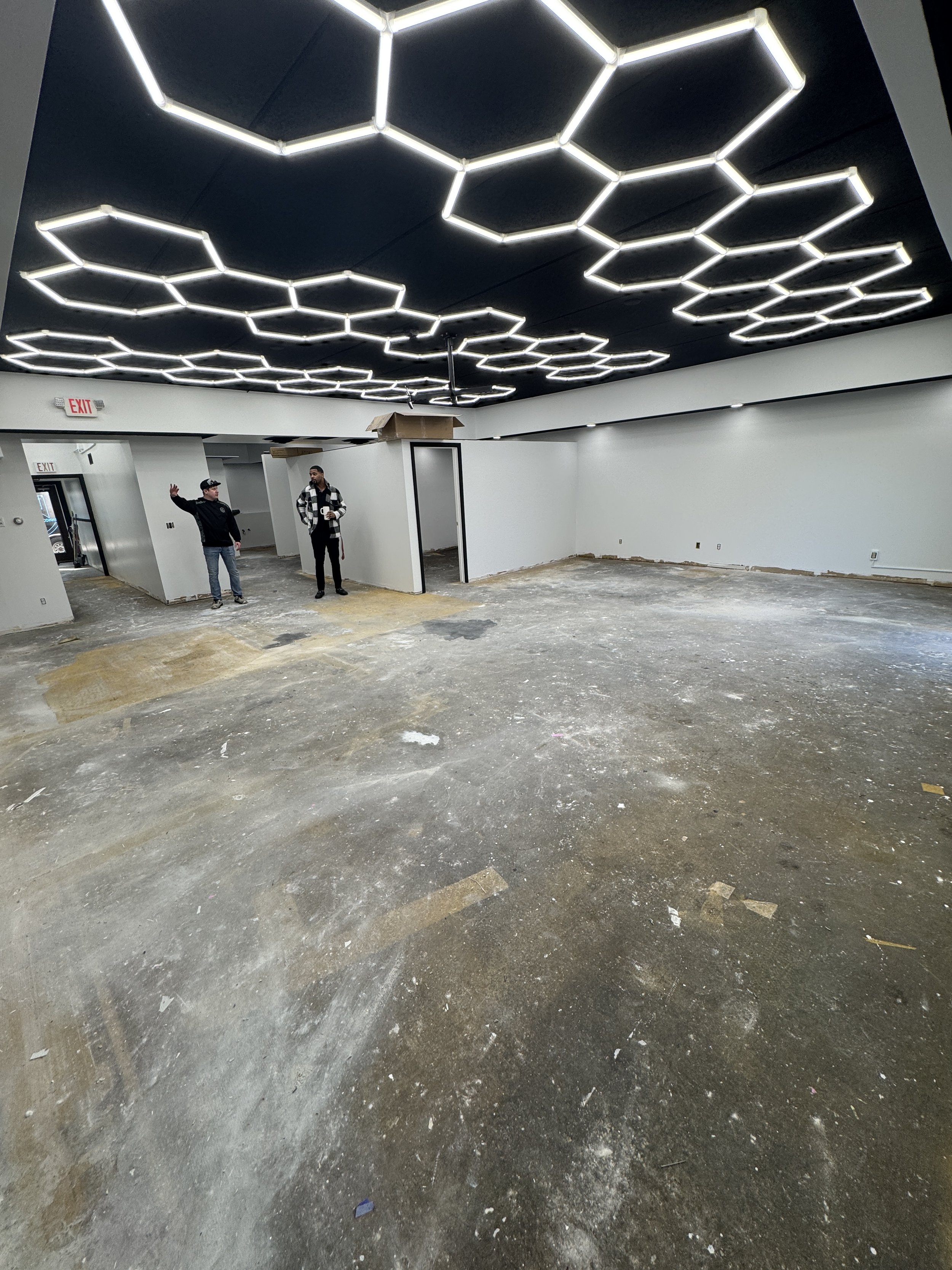Interior space with hexagonal ceiling lights and unfinished floors