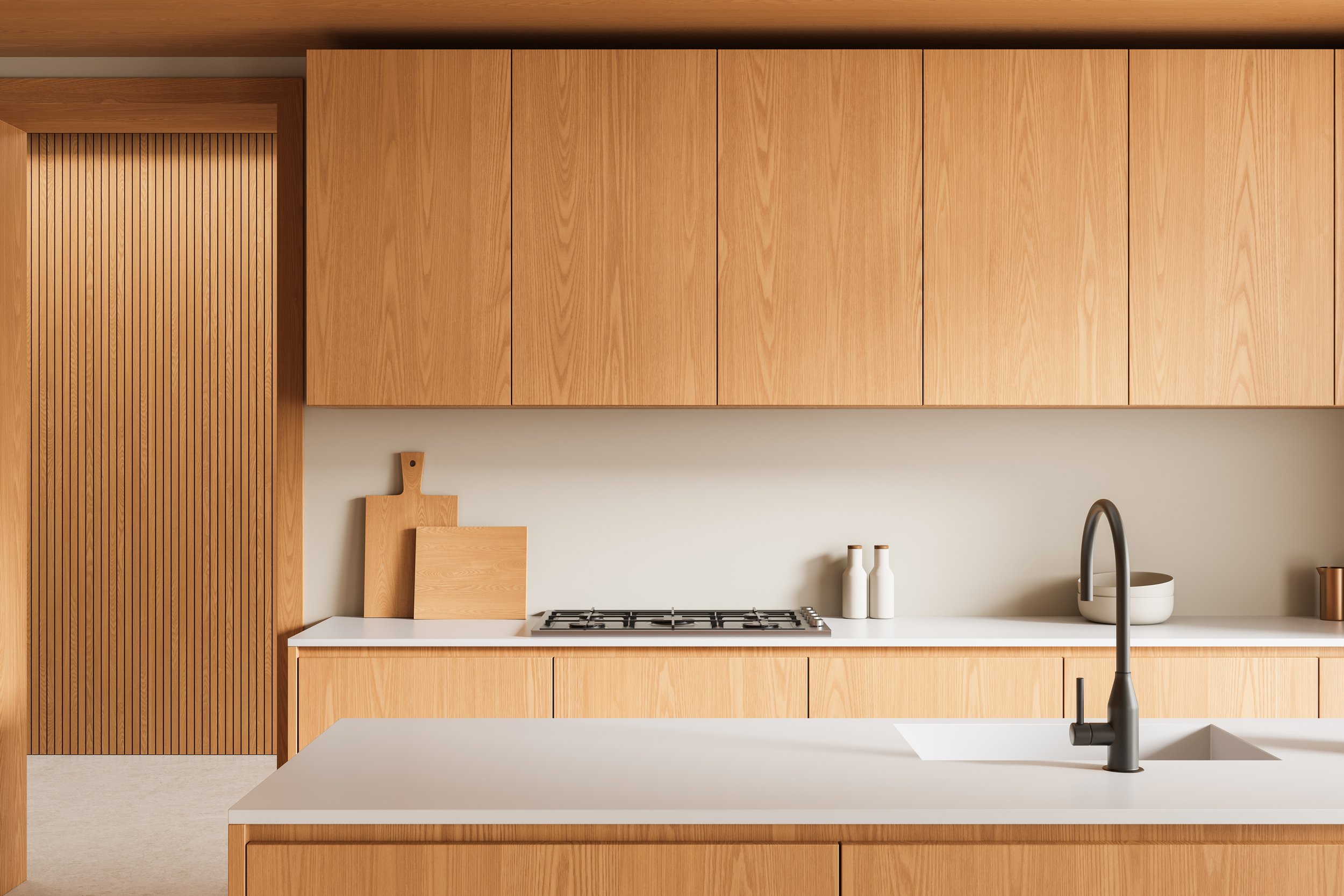 Modern kitchen with light wood cabinets, white countertop, a built-in gas stove, and a black faucet over a sink.