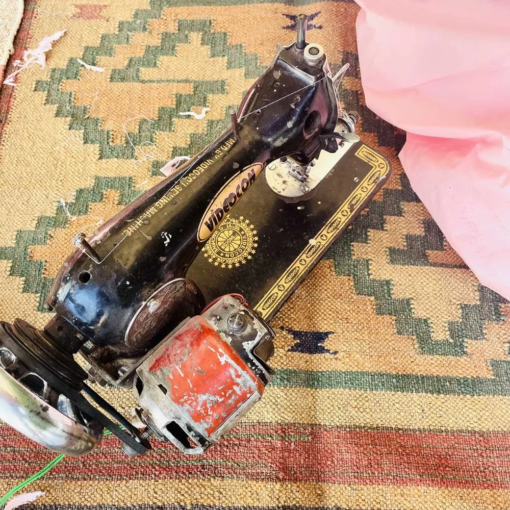 Vintage electric sewing machine by Videocon on a patterned rug.