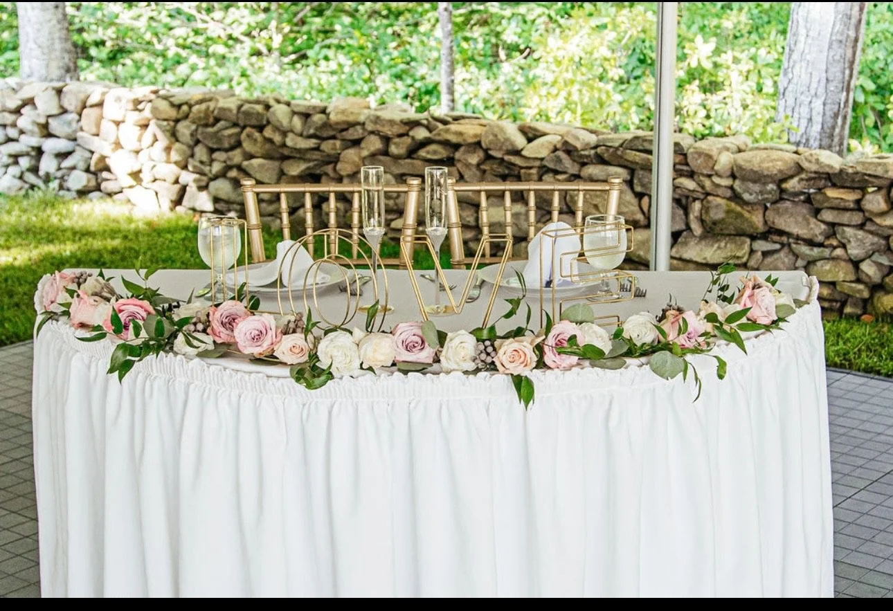 Wedding table decorated with flowers and "LOVE" sign