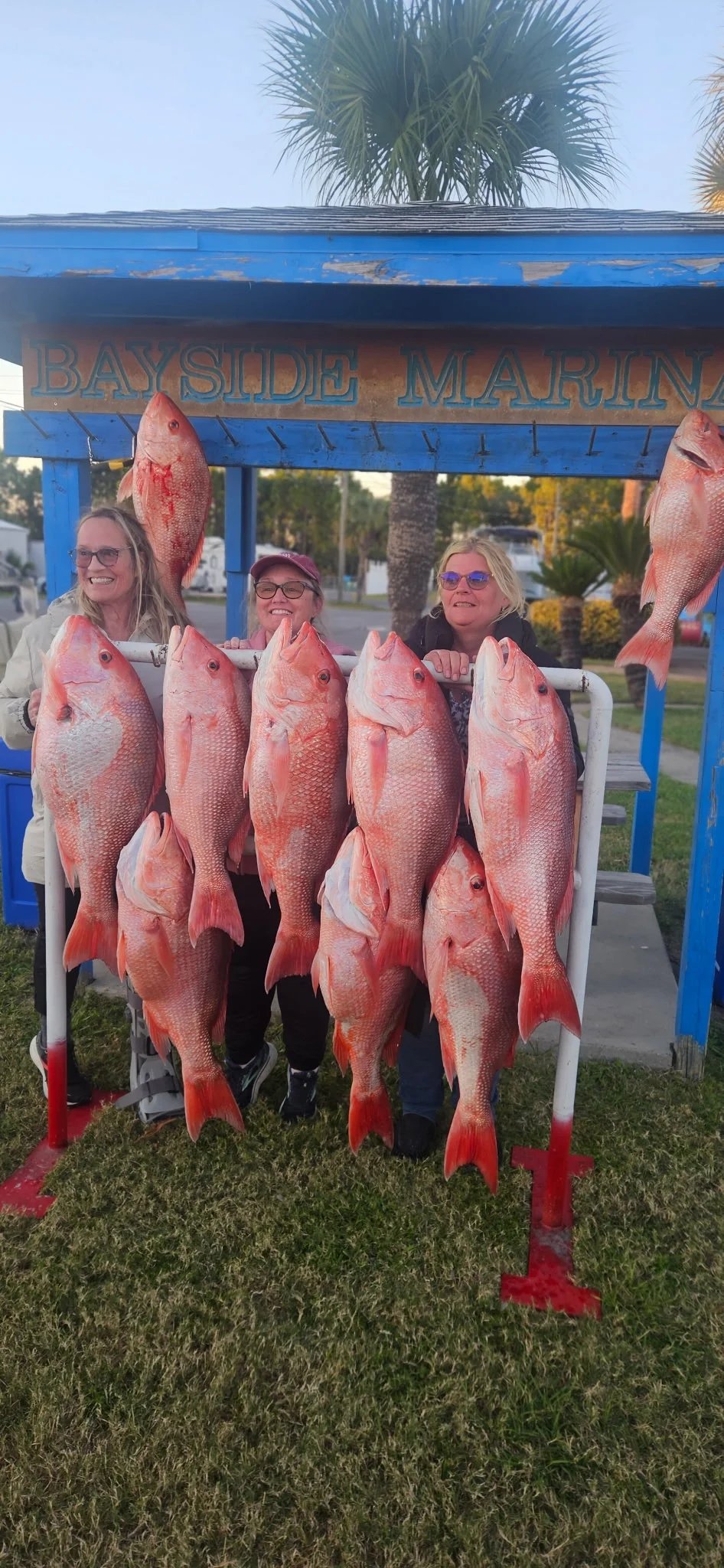 Three women on shore with their red snapper caught in the Gulf