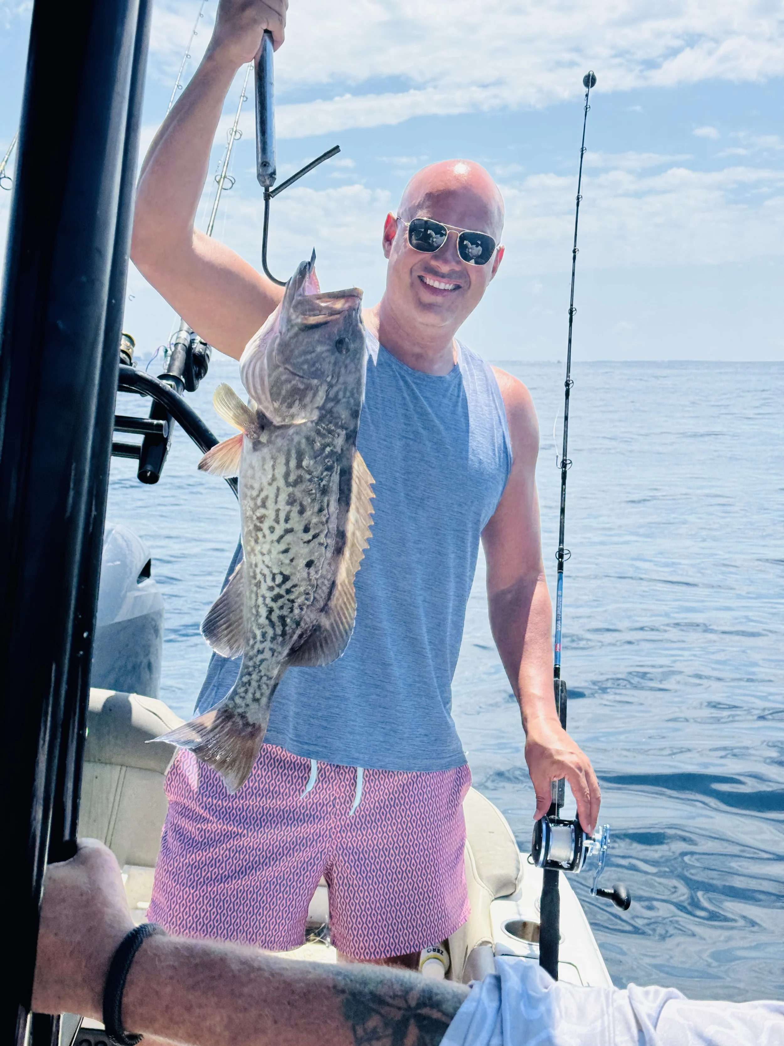 Guest holding a fish caught during an offshore fishing charter along Florida's Emerald Coast