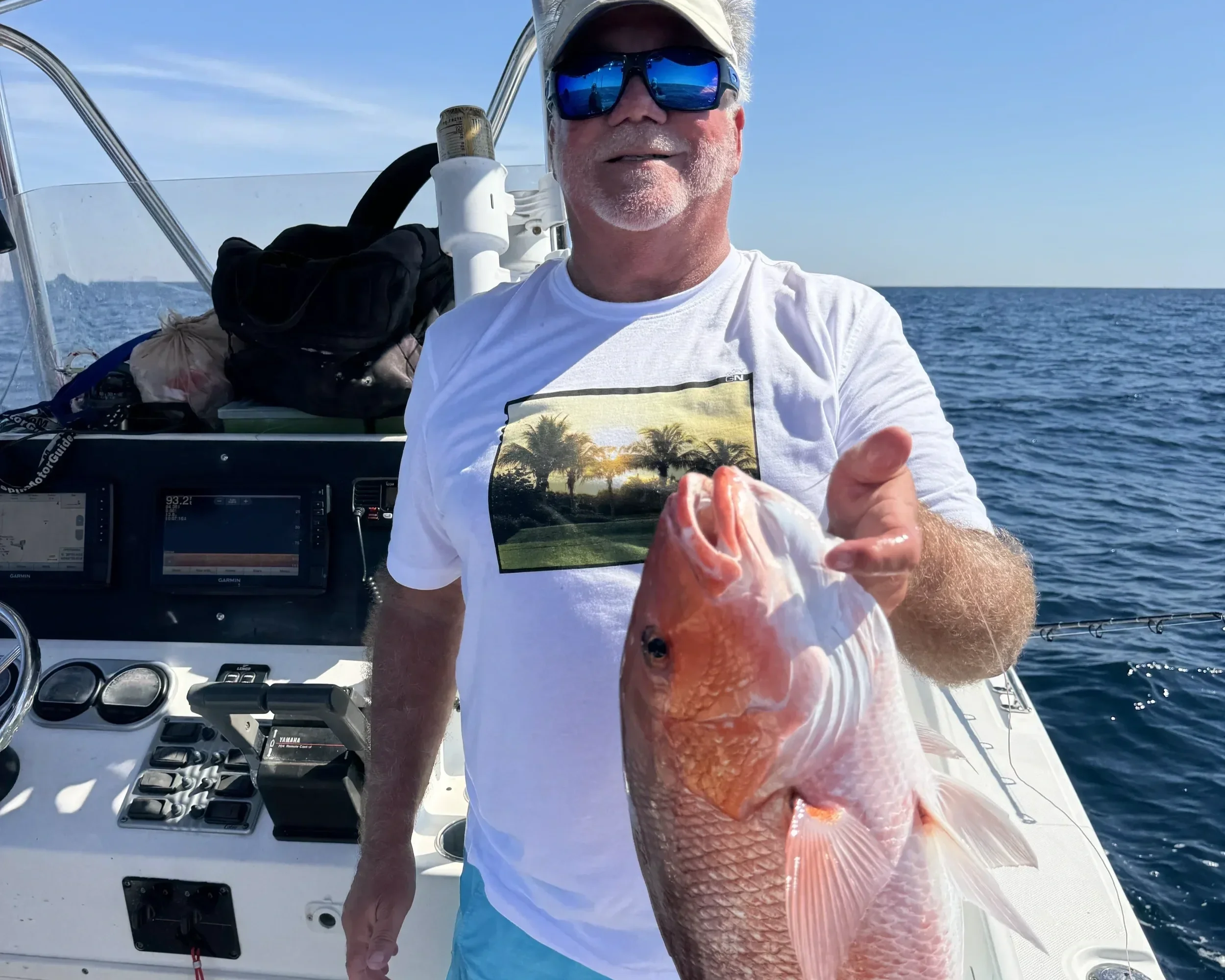 A man holds up a Red Snapper he caught along the Emerald Coast of Florida