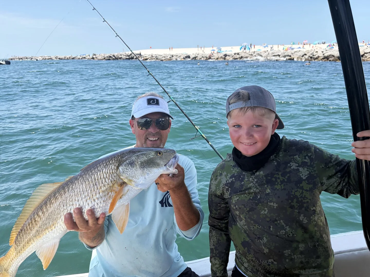 Young angler displaying a quality red redfish after a successful fishing trip with Bluewater Charter