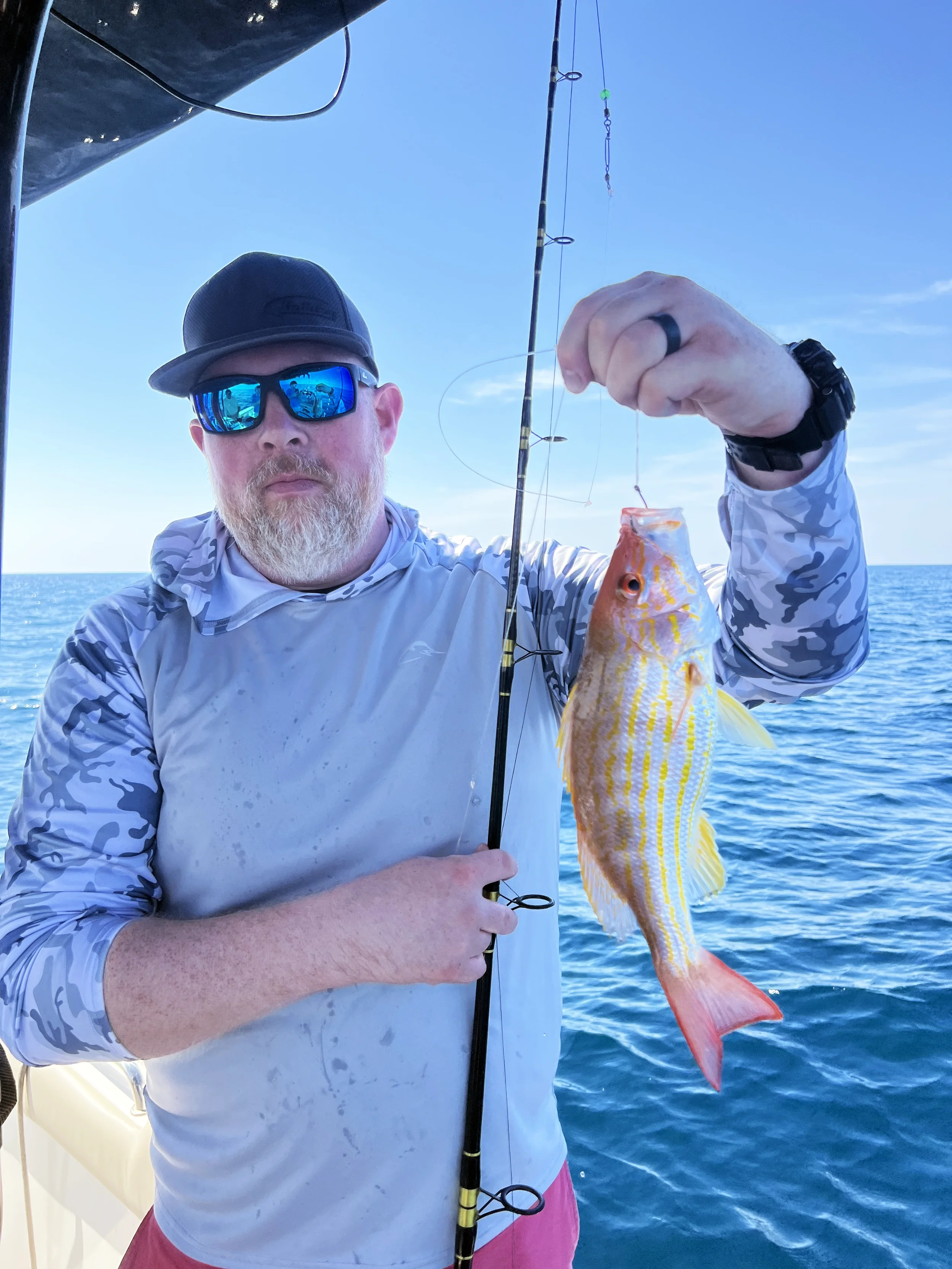 A man holds up a lane snapper he caught along the Gulf Coast of Florida