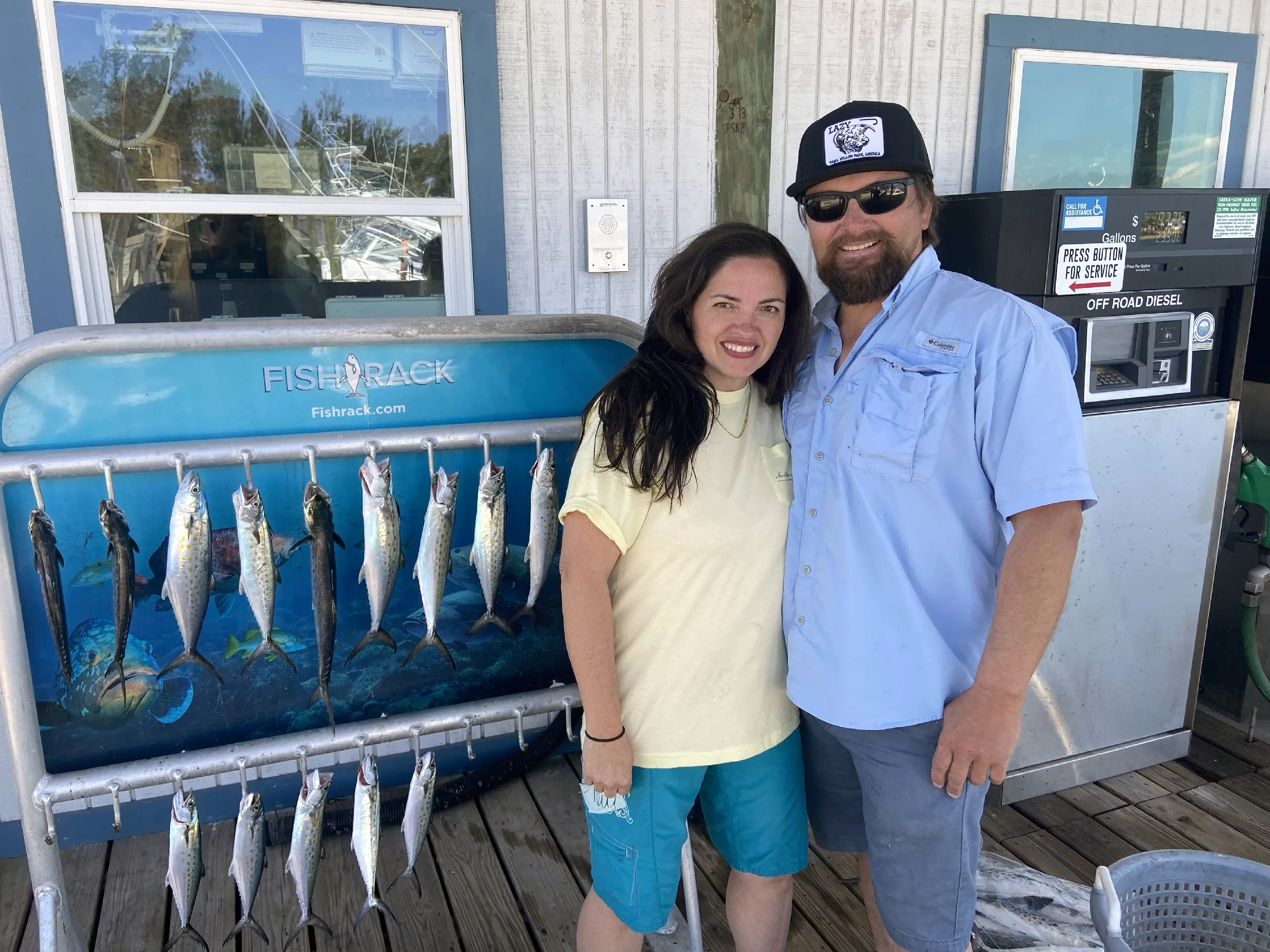 Couple standing next to the fish they caught in the Gulf