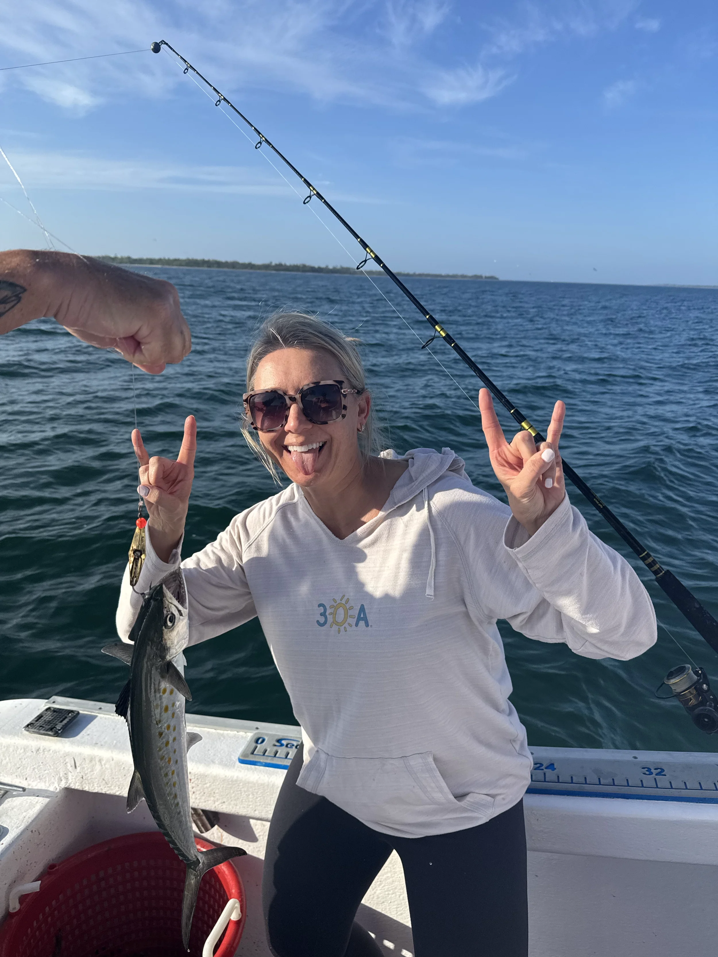 Woman making a silly face after catching a fish on a boat in the Gulf