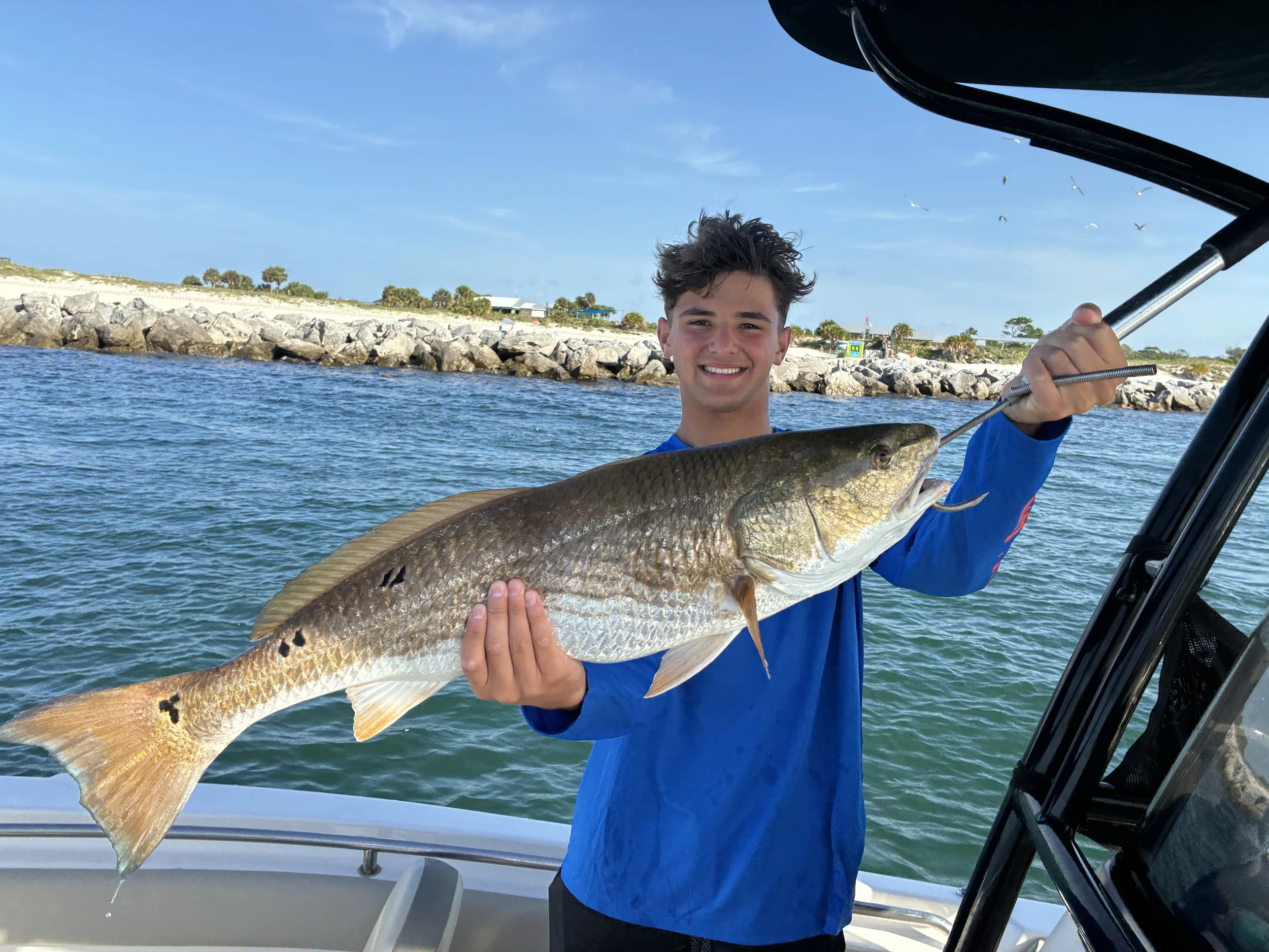 Happy angler celebrating a redfish catch during a Bluewater Charter inshore fishing trip