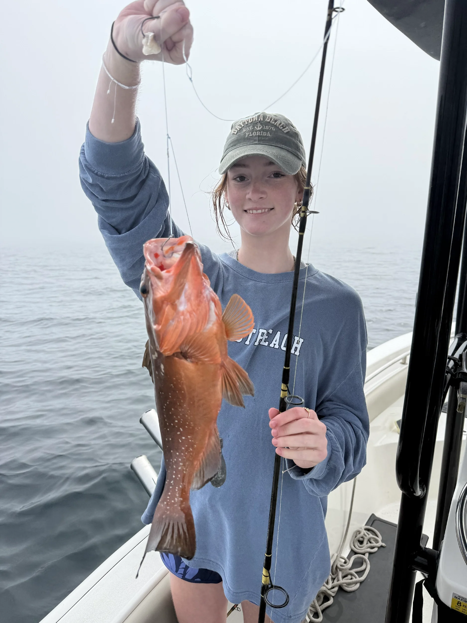 Girl holding up a red grouper she on in the Gulf