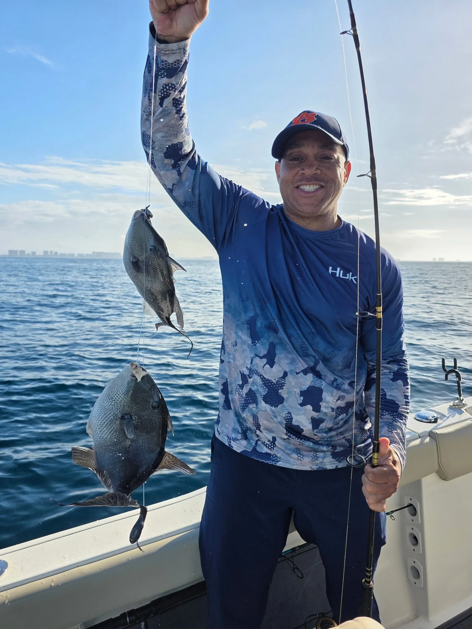 Man holding up fish on a boat in the Gulf
