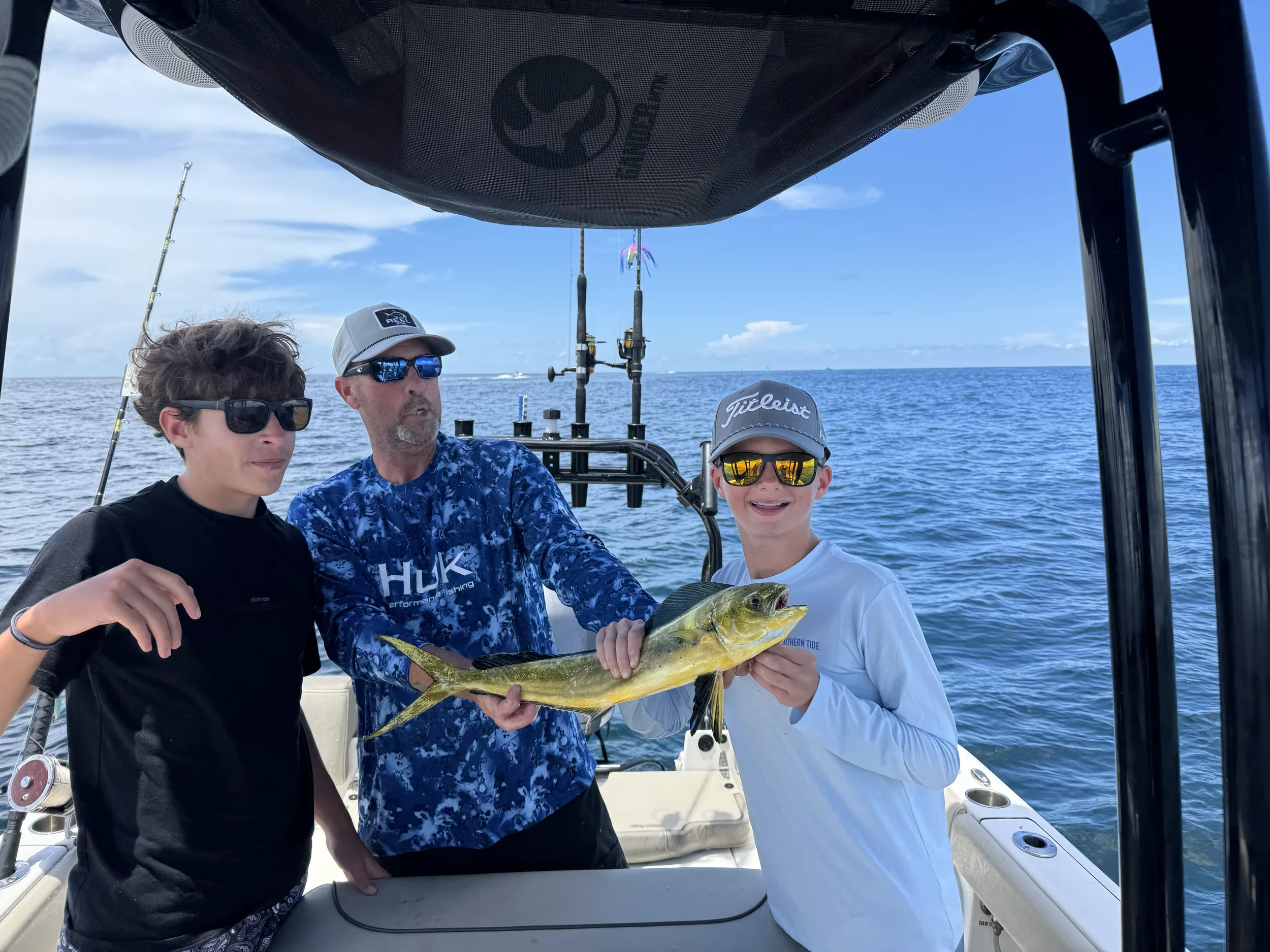 Man with teen boys and a Mahi Mahi on a boat in the Gulf