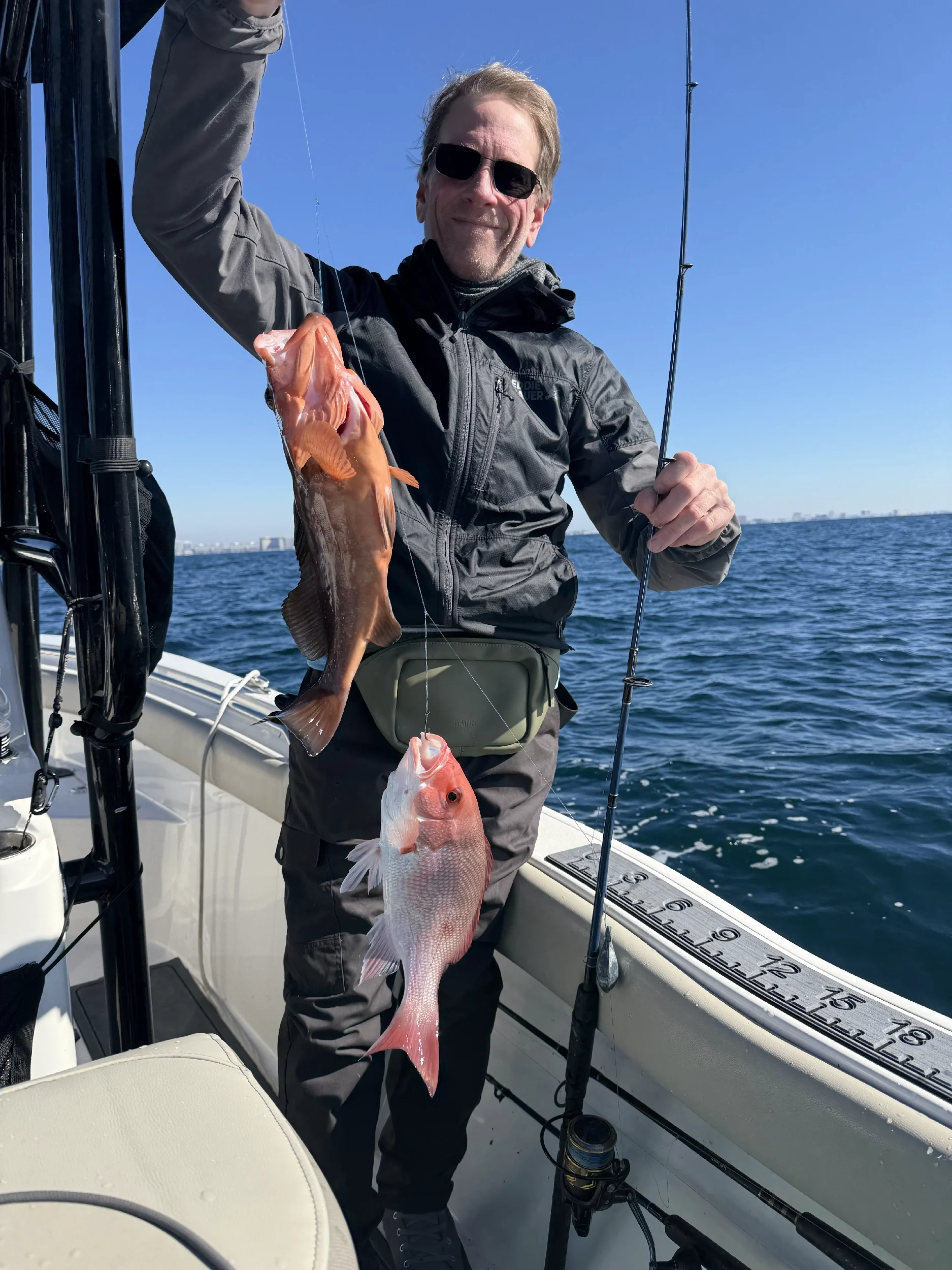 Man showing off his Gulf fish caught on a boat