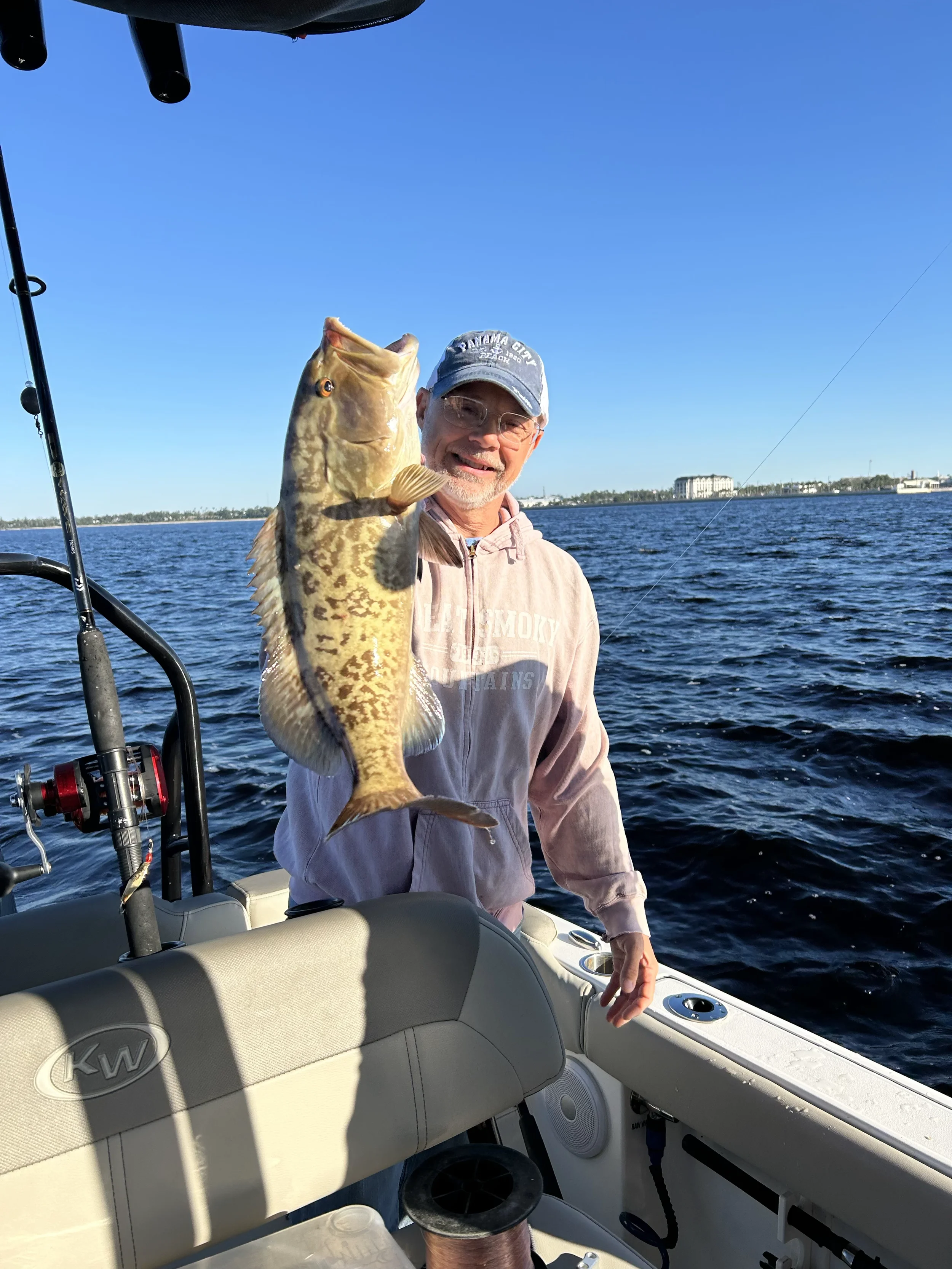 Man holding up a Grouper he caught in the Gulf