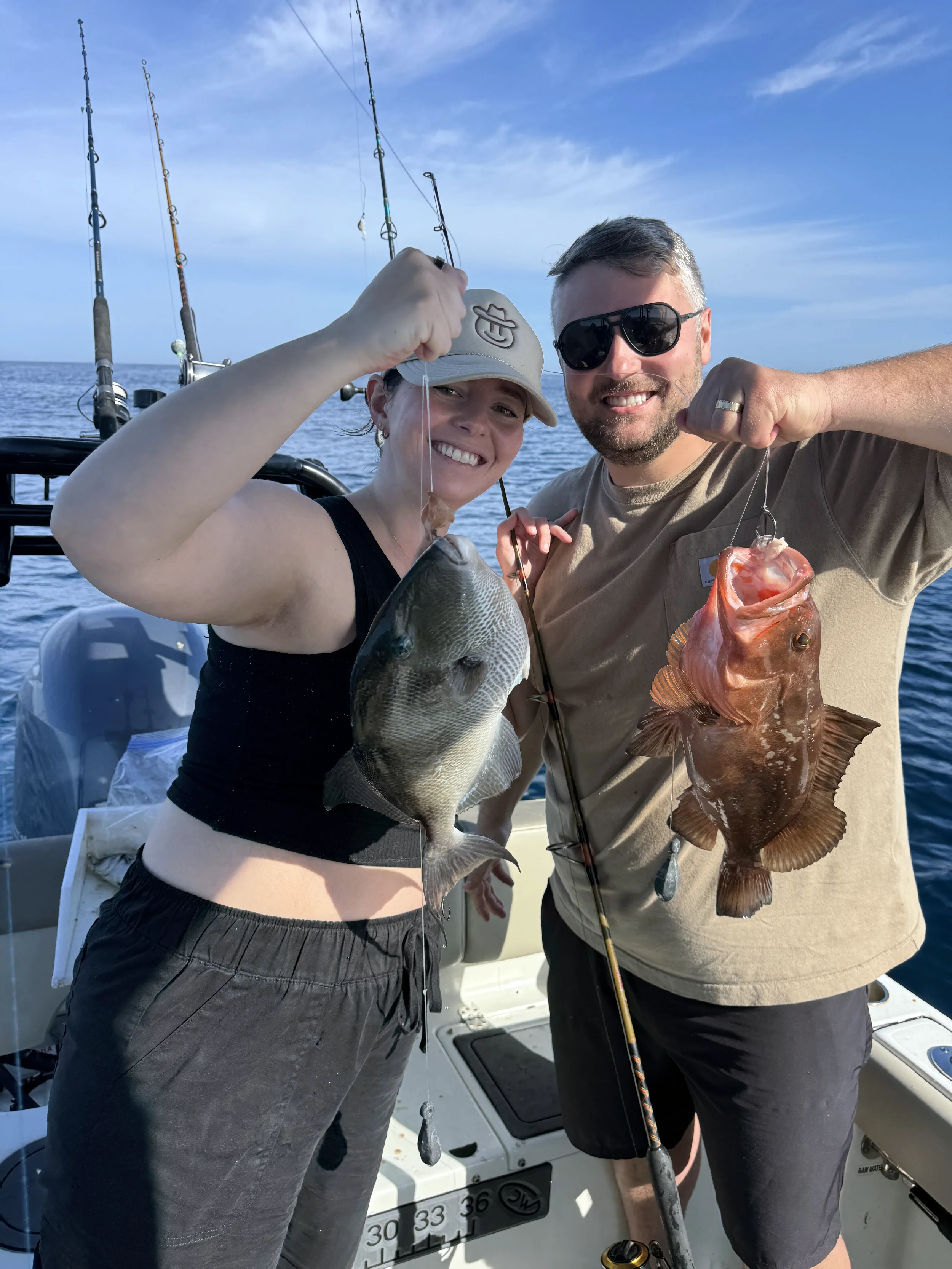 Couple holding up their fresh caught fish on a boat in the Gulf
