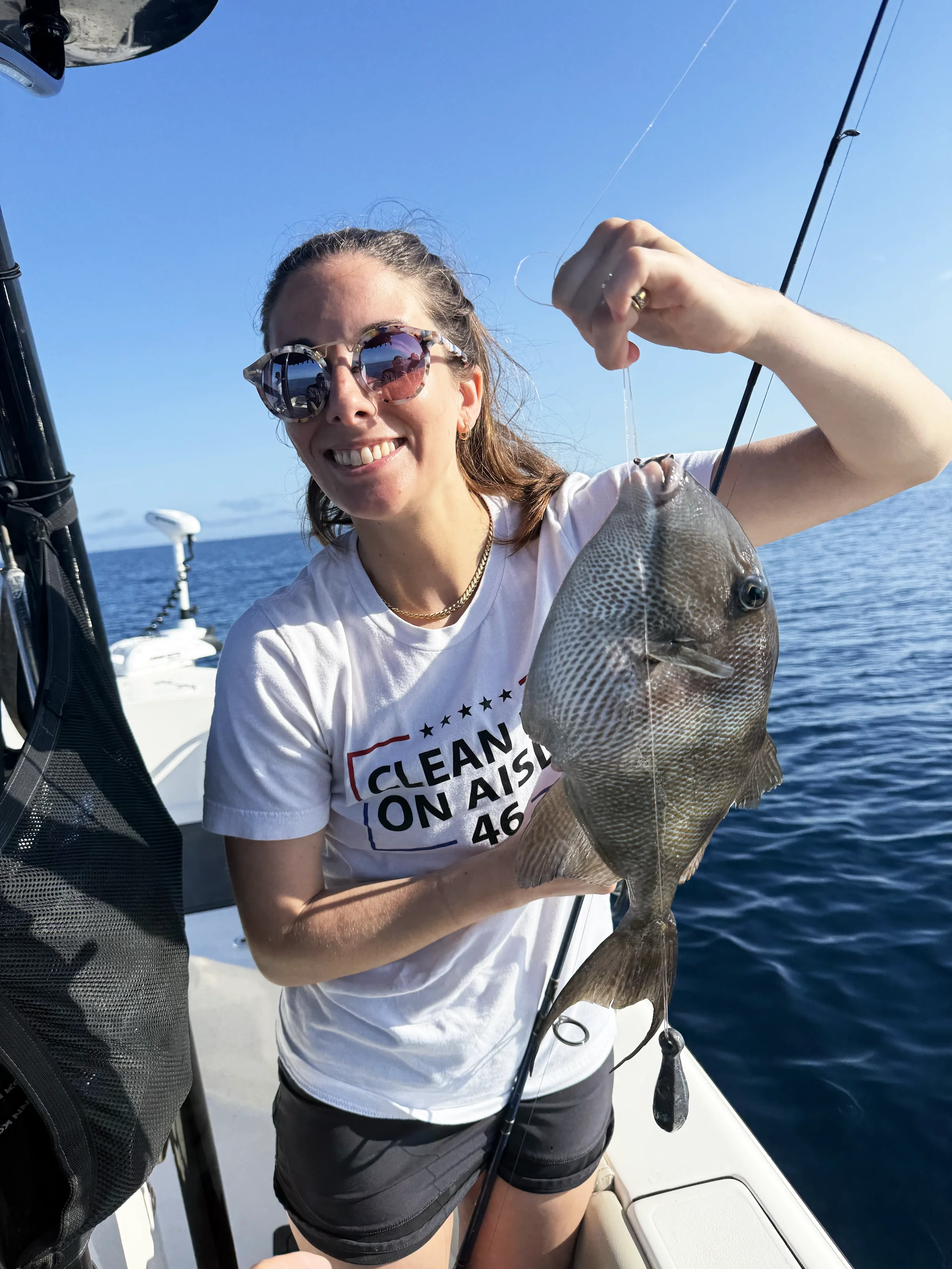A woman holds up a triggerfish that was caught in the Gulf