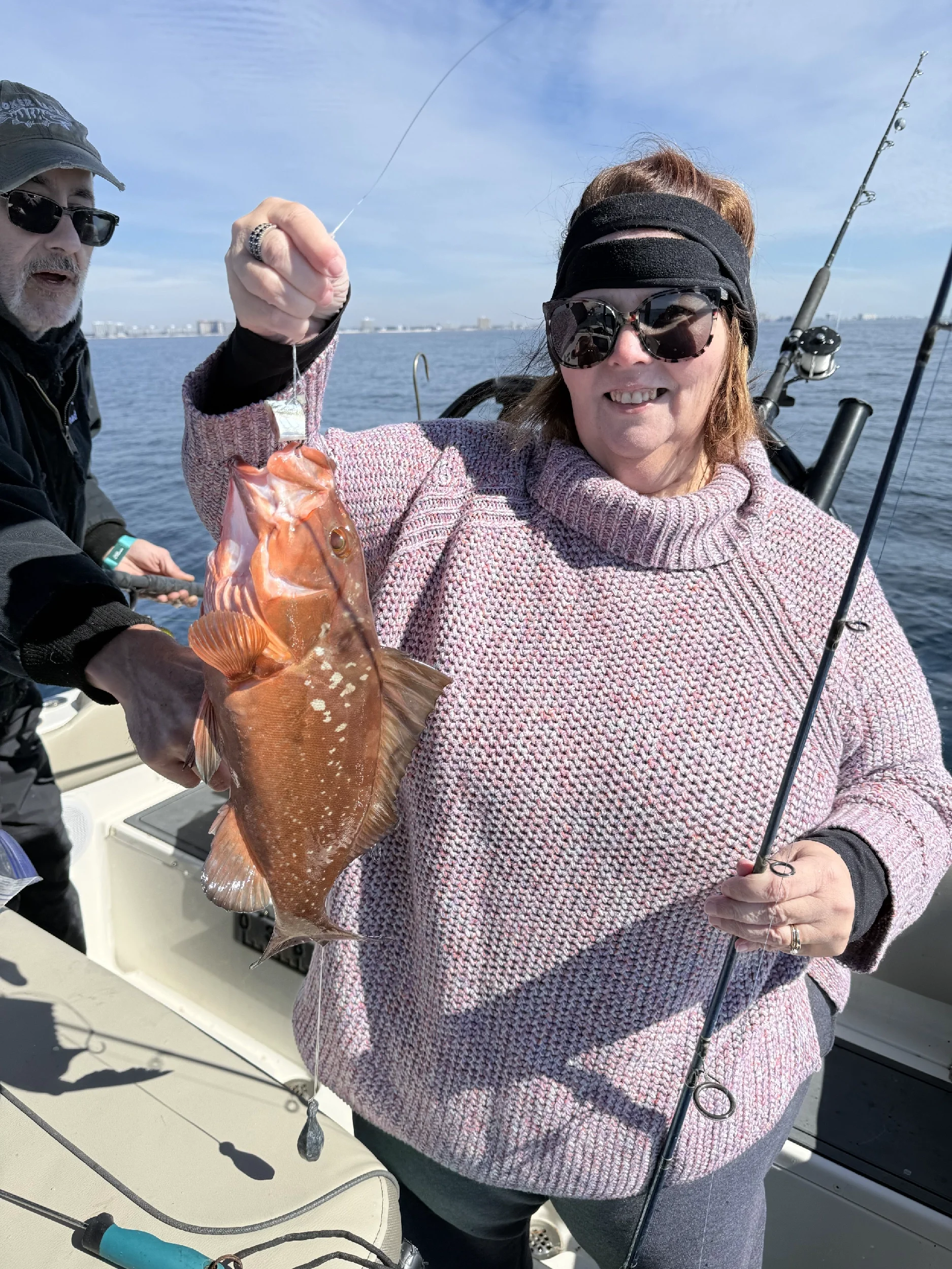 Woman holding up a Gulf grouper caught on Bluewater Charter
