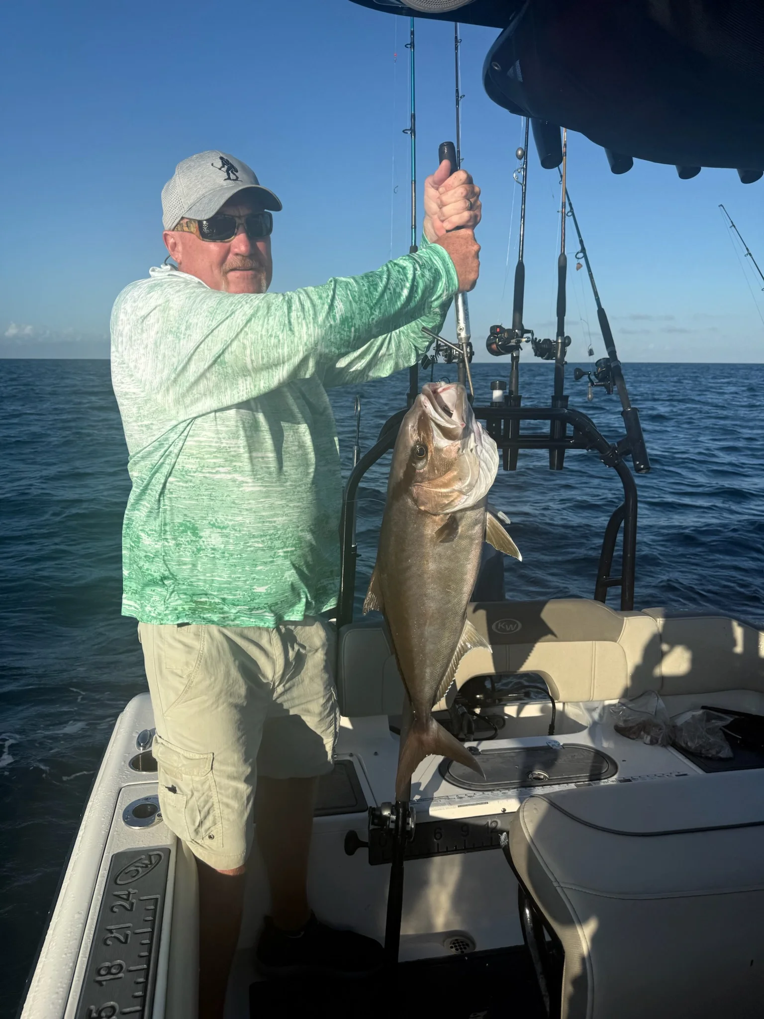 Man holding up an Amberjack on a boat in the Gulf