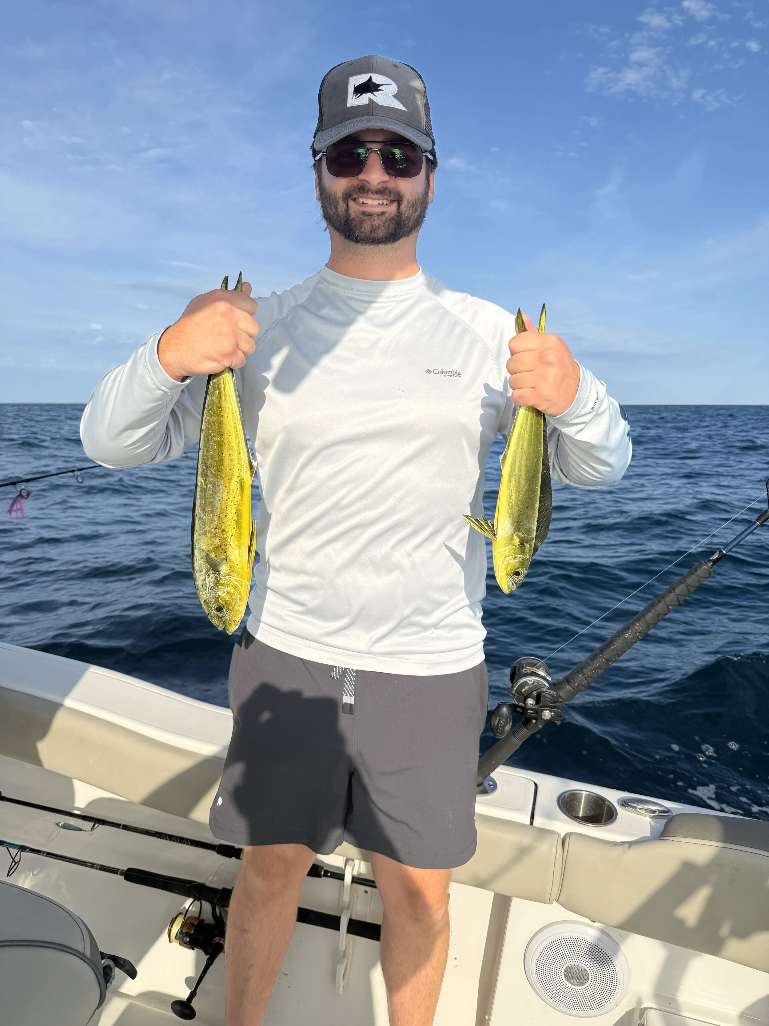 Man holding two Mahi Mahi in the Gulf