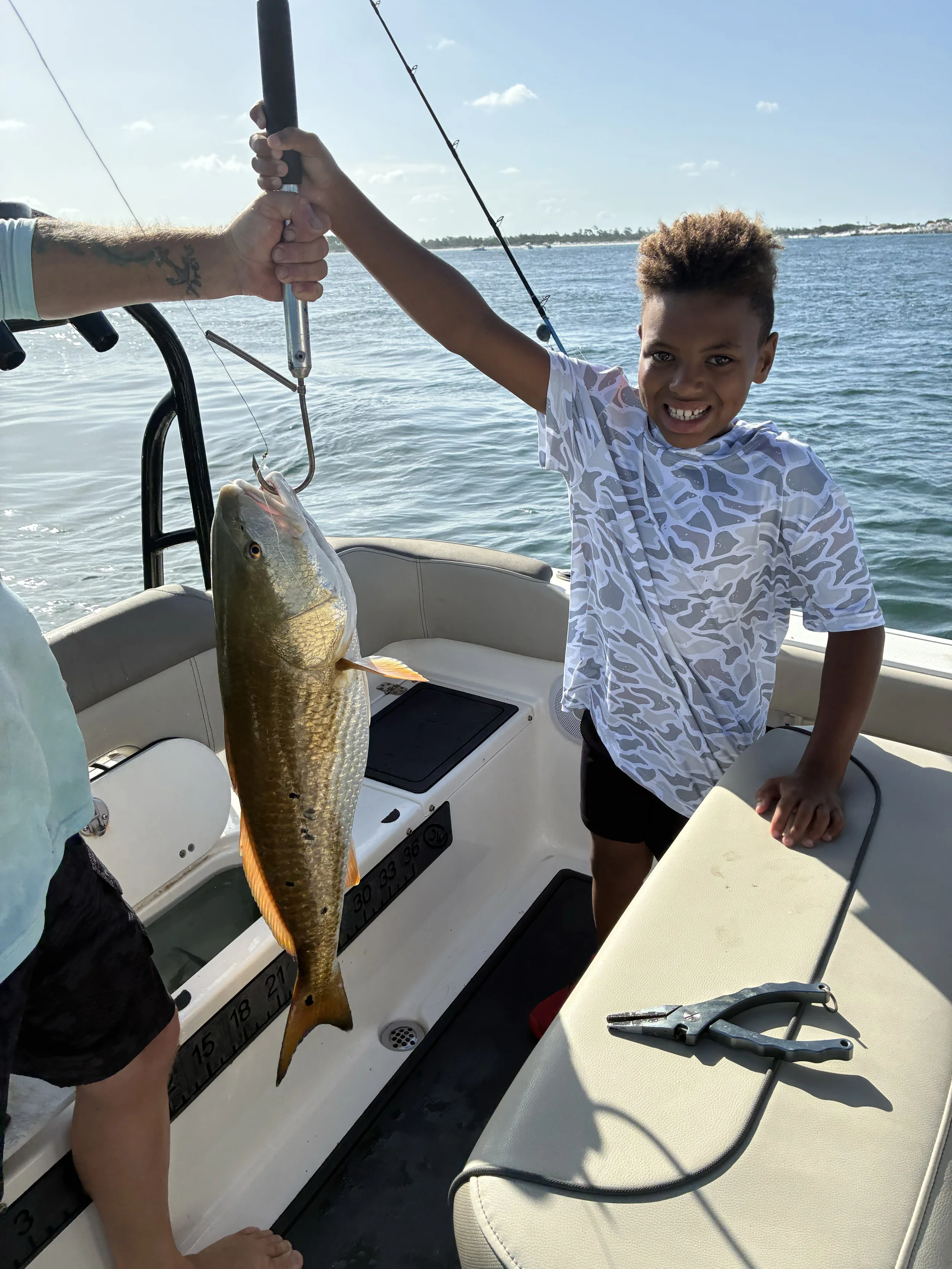 Guest proudly holding a redfish caught during an inshore fishing charter on Florida's Emerald Coast
