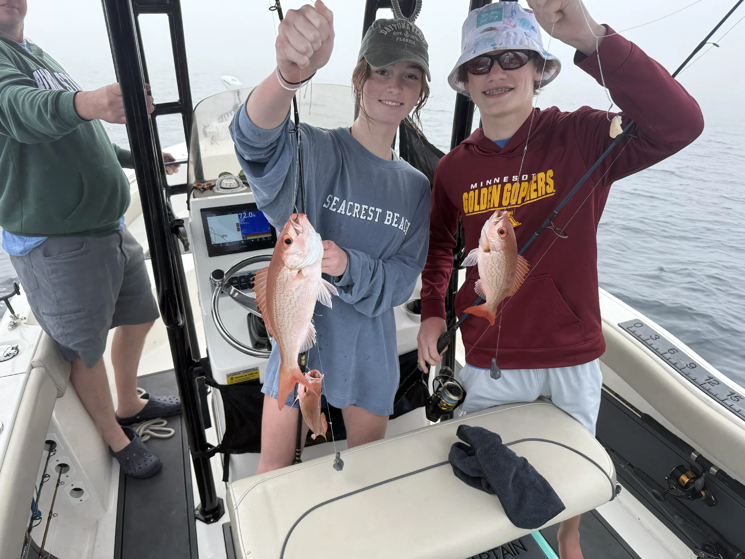 Brother and sister with fish on line caught on the gulf on Bluewater Charter